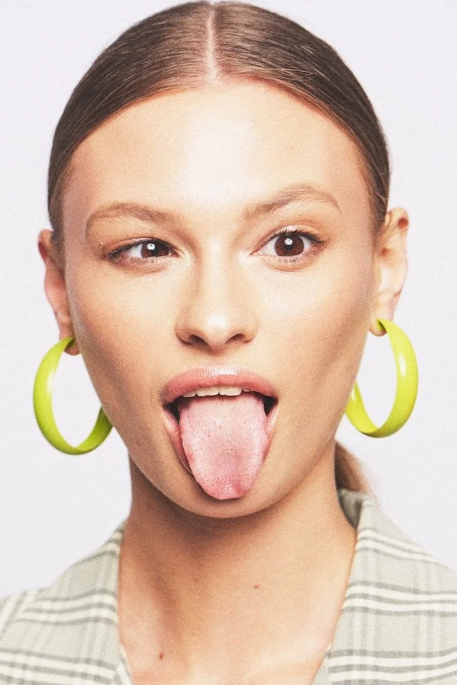 Portrait shot by Los Angeles photographer  Nik Williams - Tongue out - earrings 