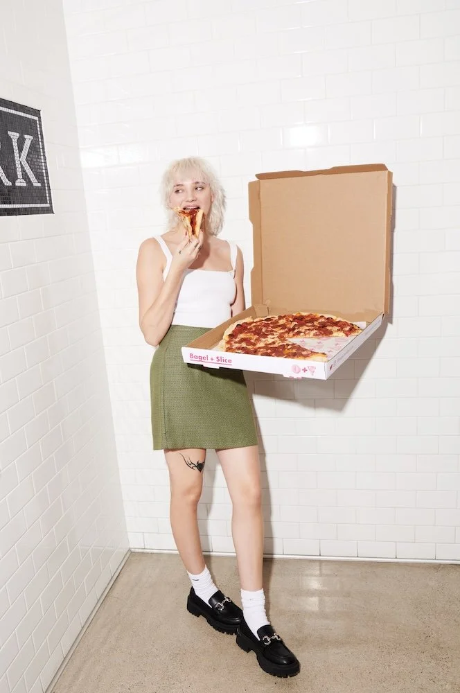 Oly Maly eating a slice of pizza by Nik Williams in Los Angeles CA
