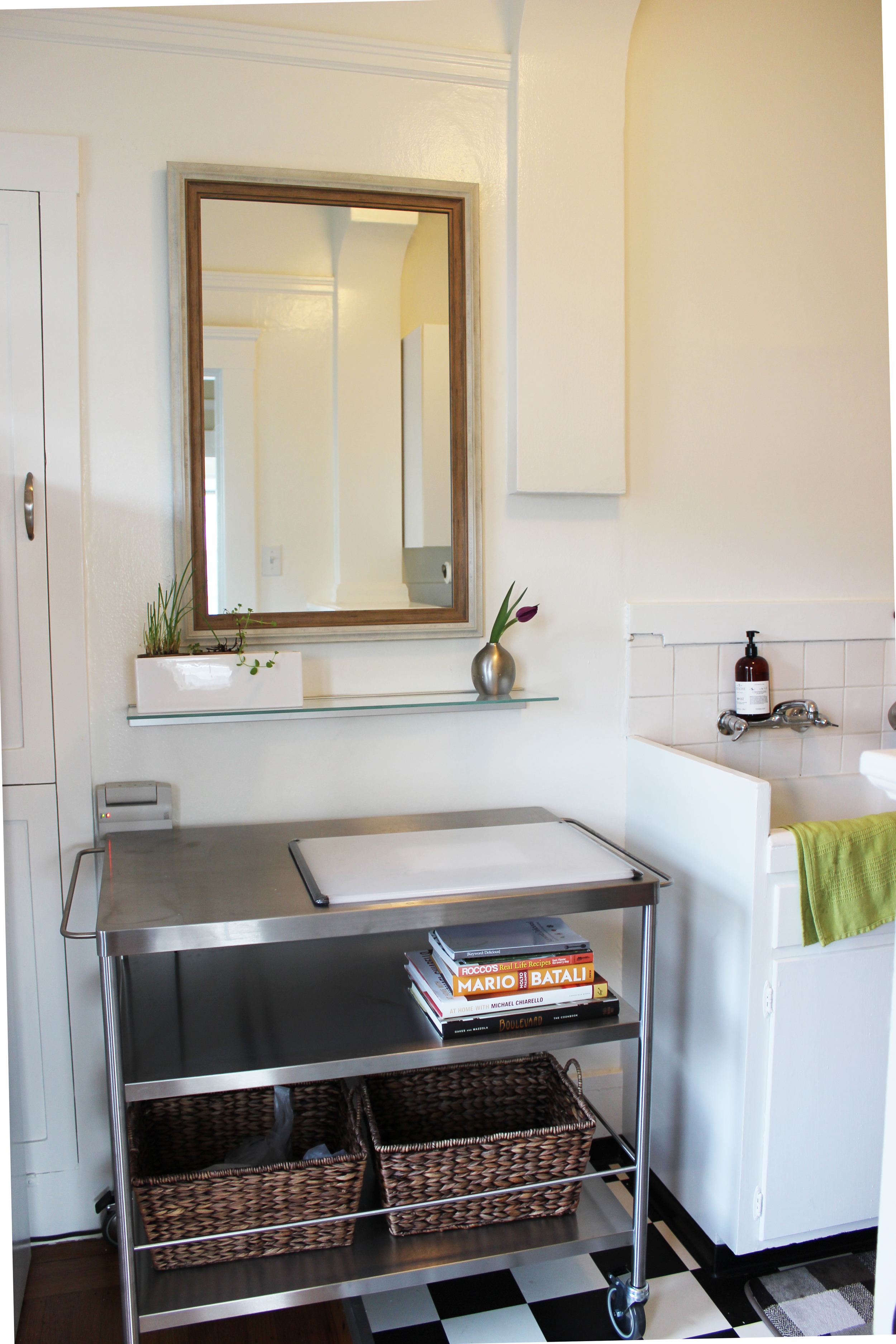Such a cheerful kitchen. The kitchen island is easy to keep clean with baskets for storing fresh produce, and the wall-mounted shelf is ideal for herbs, oils, and other kitchen necessities. Don't you agree that the mirror makes the room brighter?