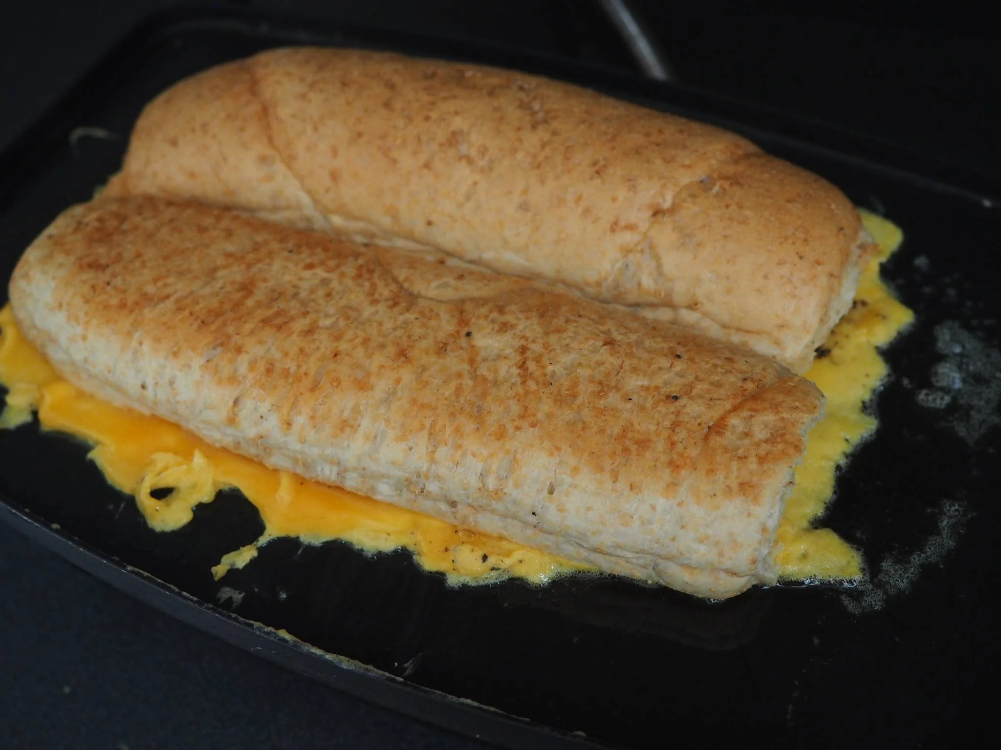 Cooking the roti john on sandwich press
