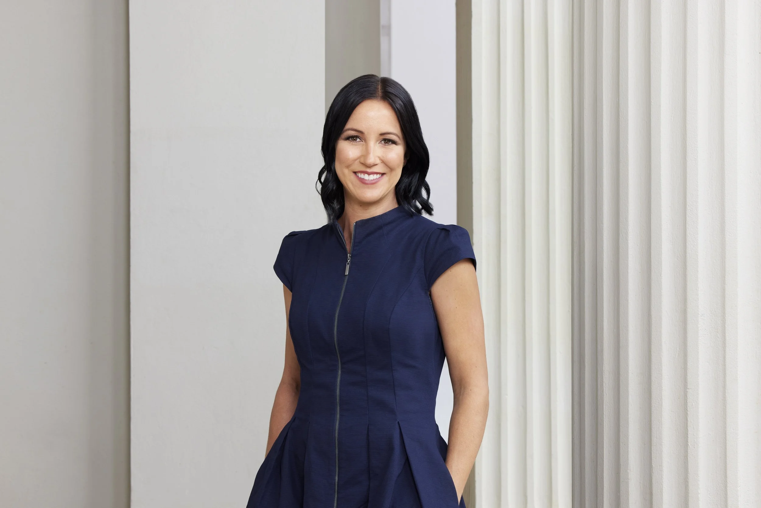 Portrait of real estate agent in navy blue dress on a background of pillars