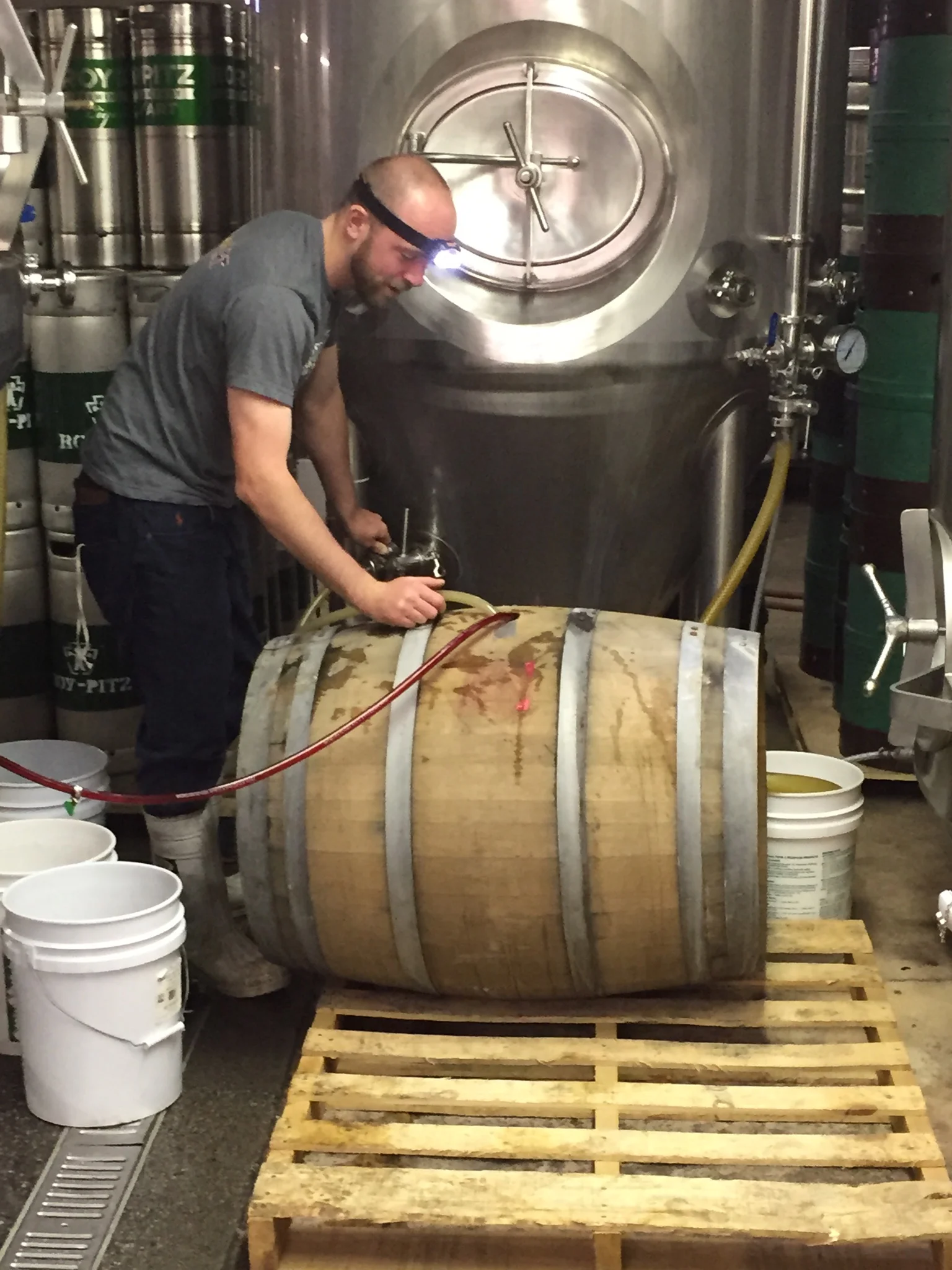 Chris Collier filling a white wine barrel with Mind Your P's and Q's