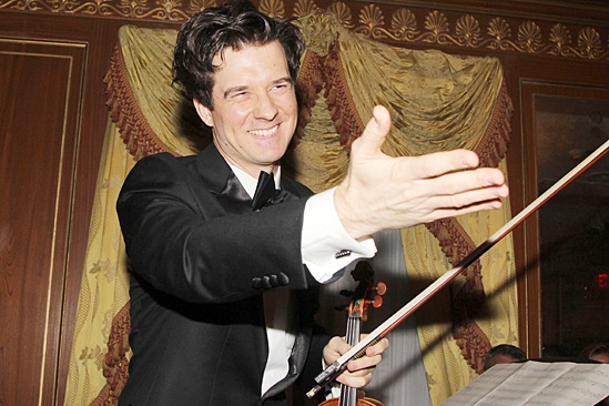 Violinist Christian Hebel pauses to salute the man of honor.