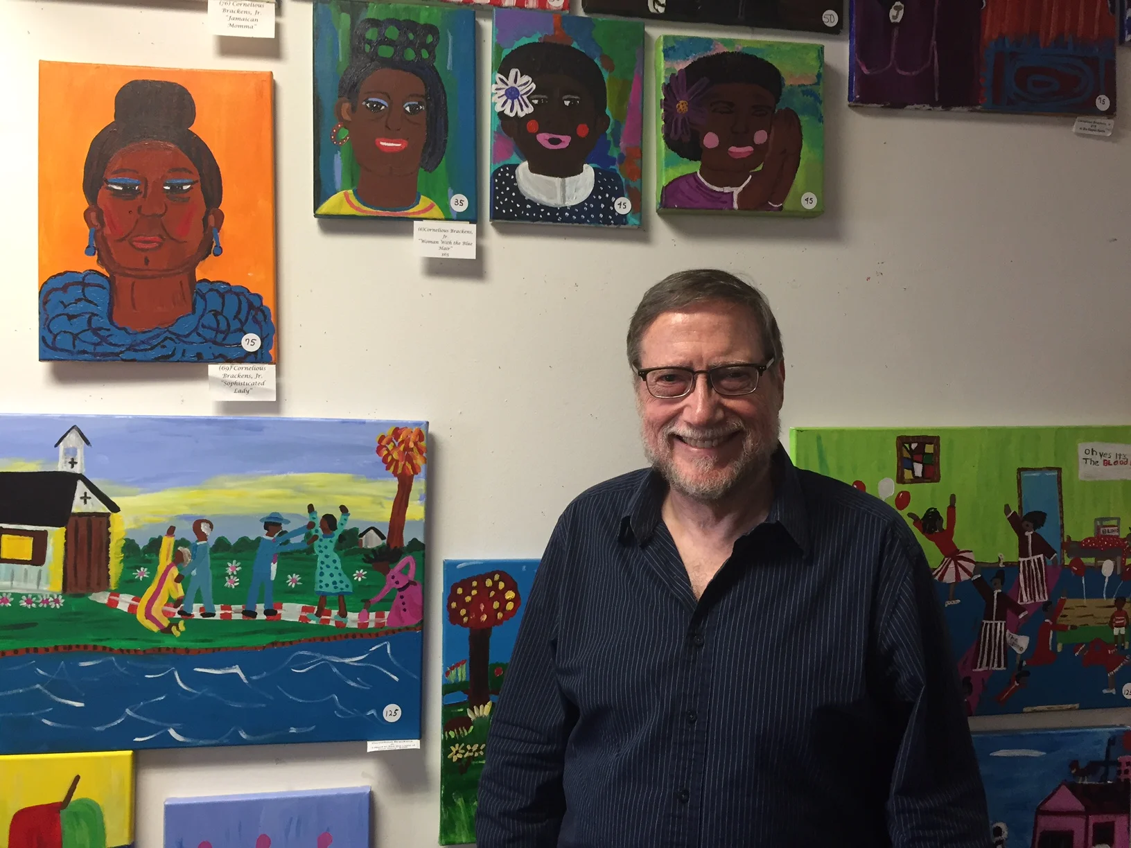 Bruce Buchanan, executive director of the Stewpot, stands in front of just some of the art displayed in the homeless center’s second-floor gallery. (Hunter Johnson/Staff Contributor)