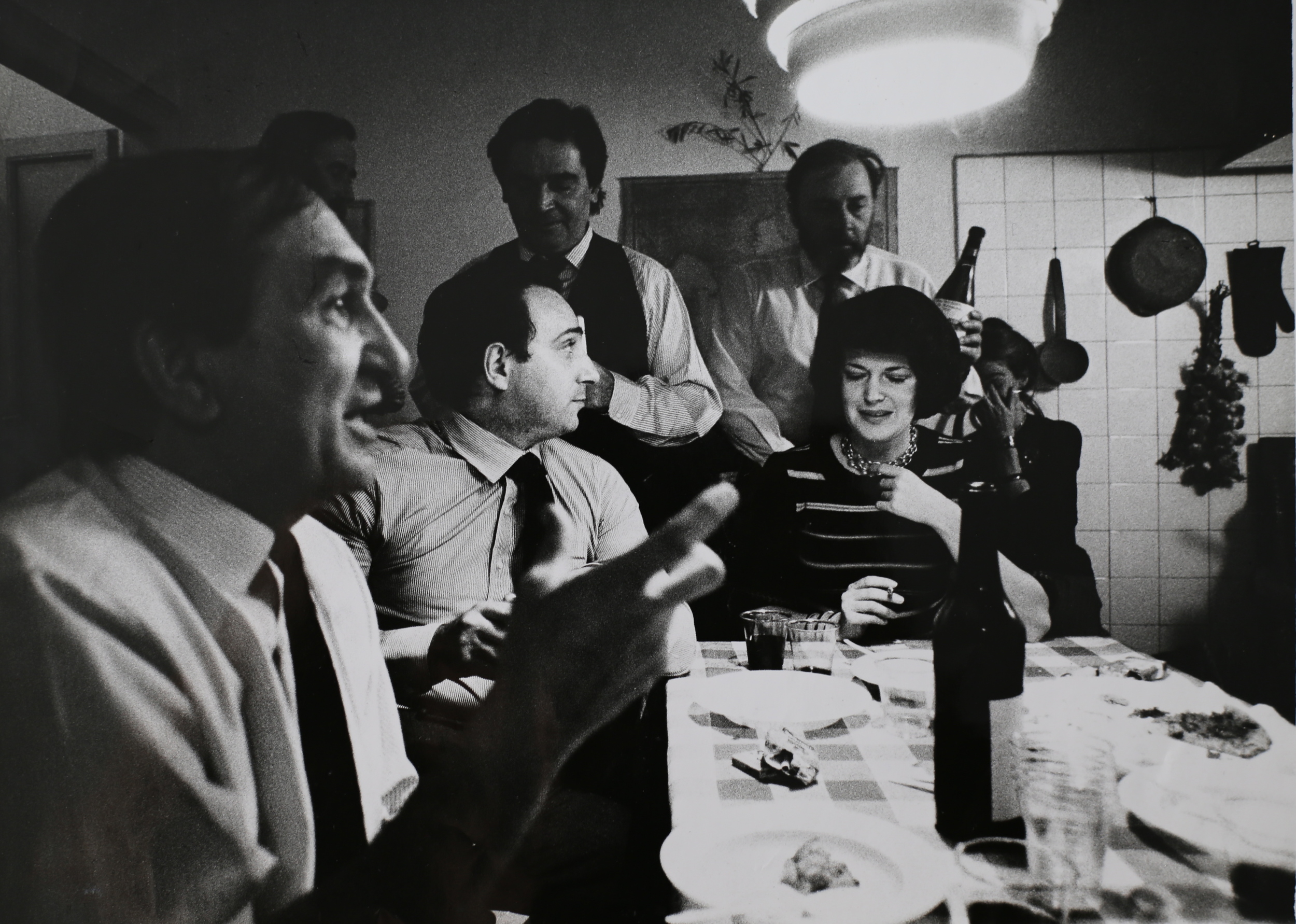   Marco Zanuso (primo piano, architetto e designer), Paolo Fossati (seduto, critico d'arte), Roberto Sambonet (in piedi a sinistra, grafico), Guido Sambonet (in piedi a destra), cena a Casa Sambonet. Milano, 1973.  