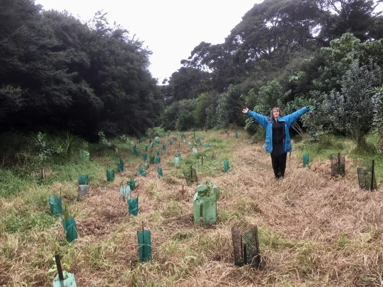   Kate Waterhouse beside riparian plantings established and new – Okiwi river, July 2022 (Credit: Rohan MacMahon)  