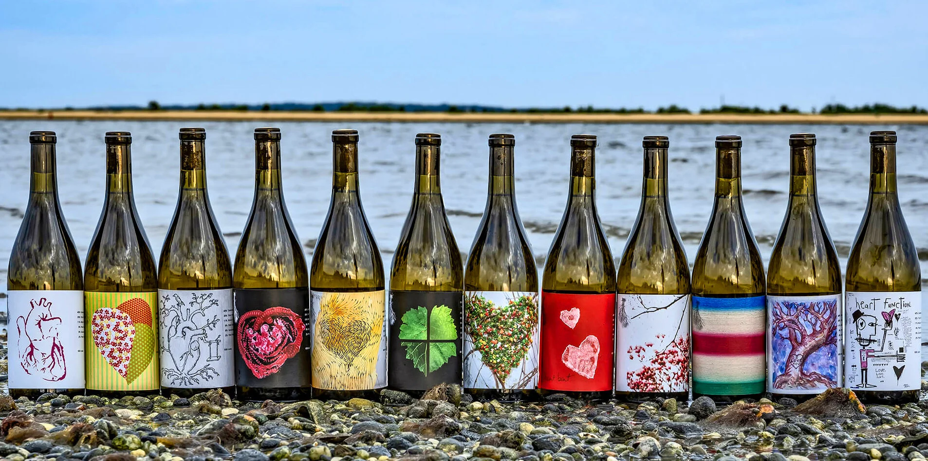 2019 Heart Artists Series wine bottles lined up on the beach
