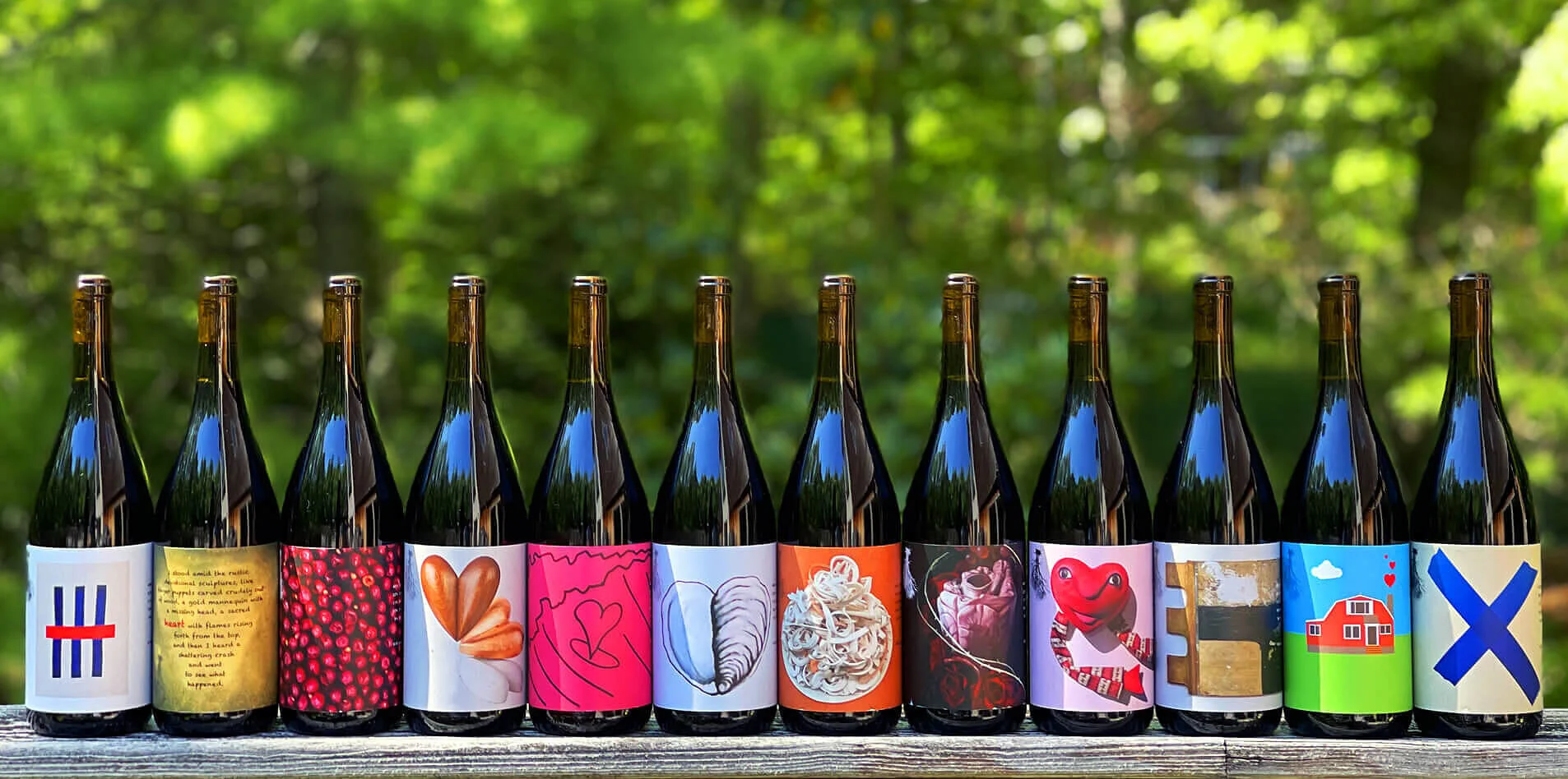 2020 Heart Artist Series bottles lined up with lush trees in the background