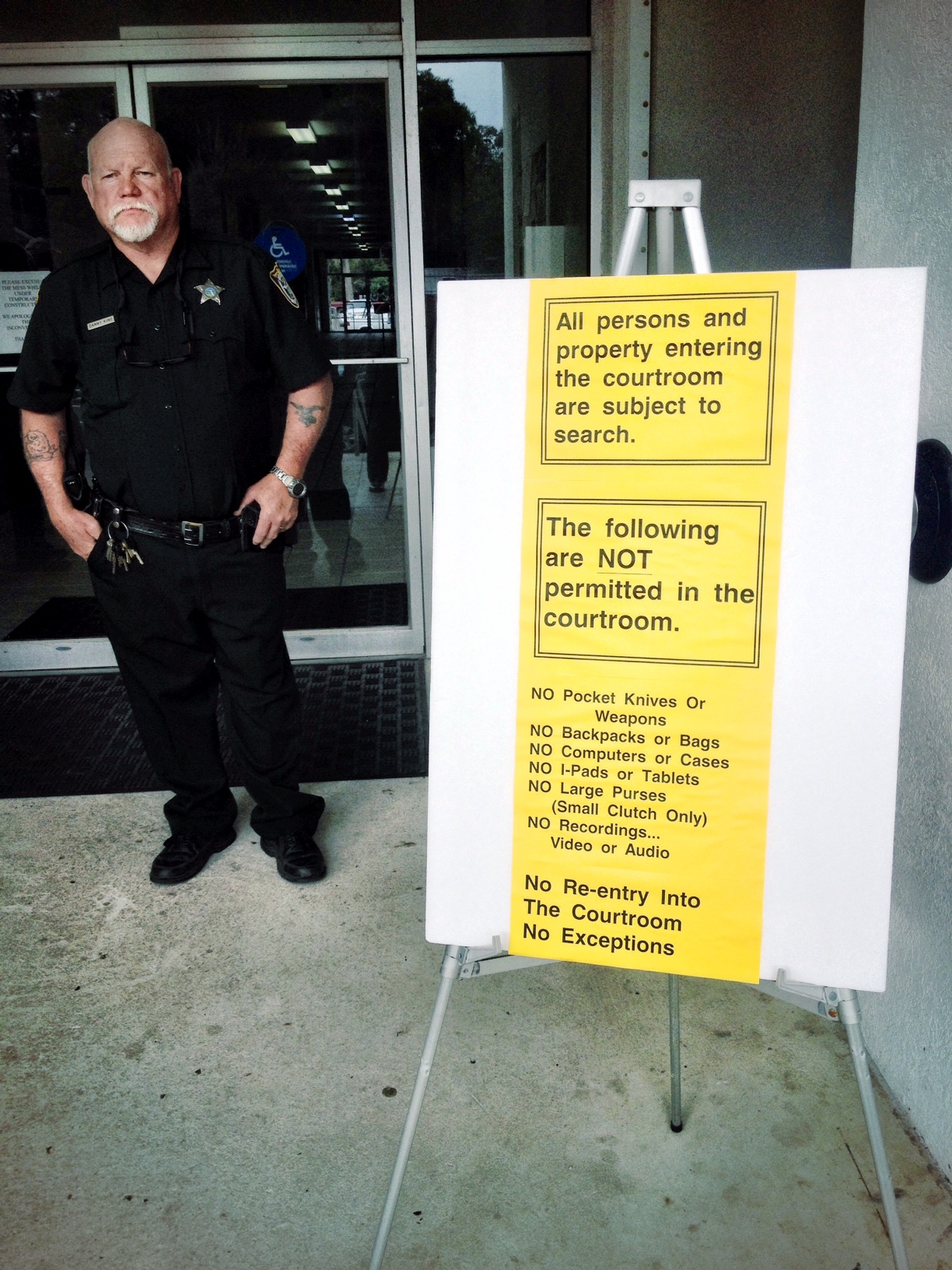 With the same reply used when rounding up the Jews, Dixie County Deputy ignores the Constitution saying, "I'm just following orders" standing next to a sign before entering their secret society.