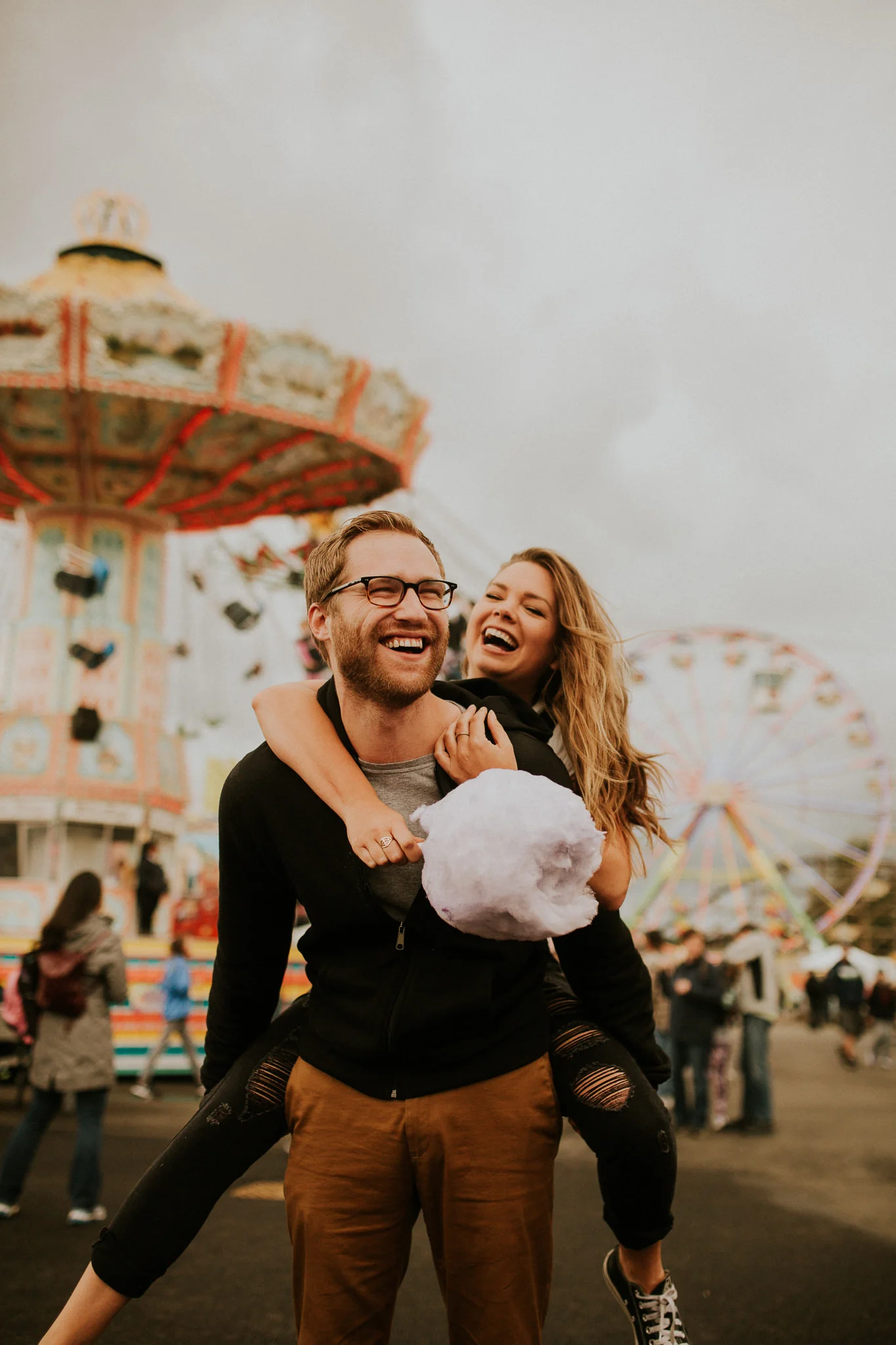 moody warm state fair engagement photography with cotton candy.