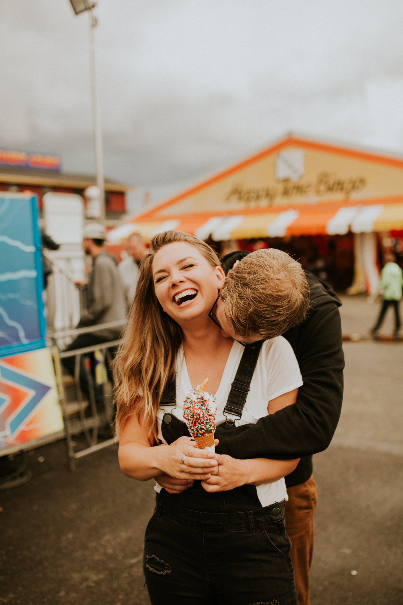 State fair summer nights vibes with a cute couple having their engagement photos taken at the puyallup fair with an icecream cone.