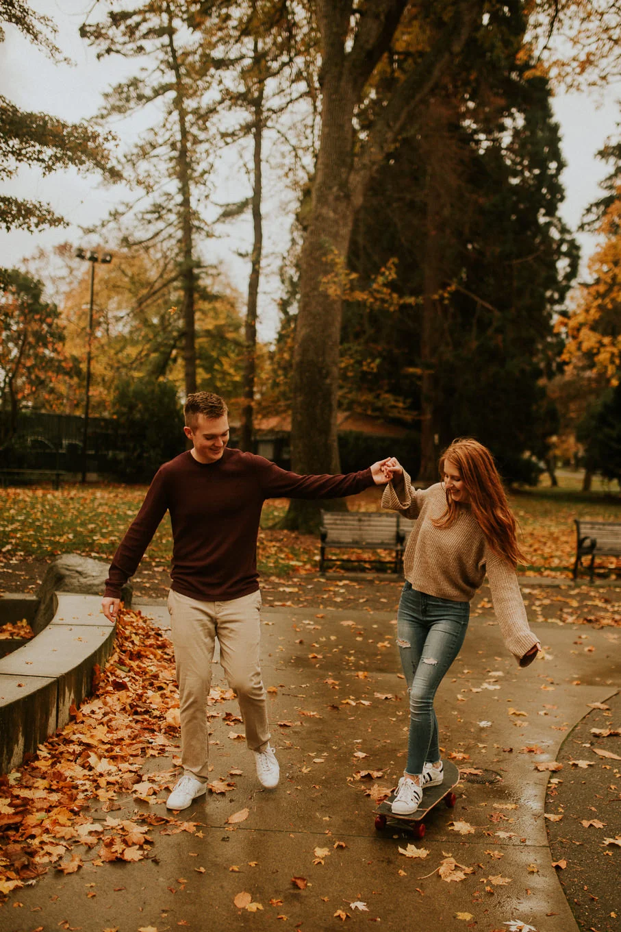 Engagement photo of couple kissing in the rain PNW weather byWright park Tacoma Washington