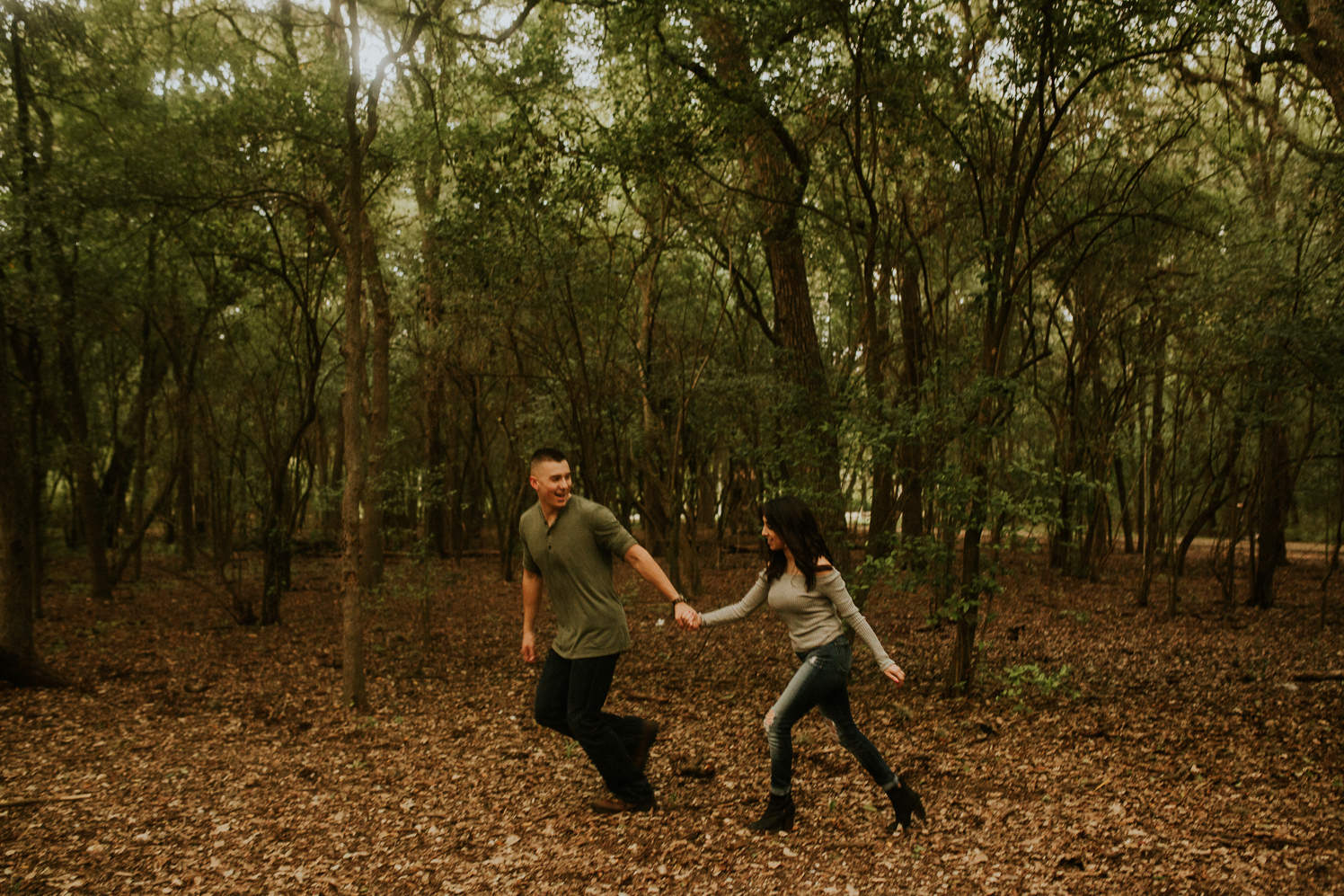 san antonio engagement photography couple running in the woods