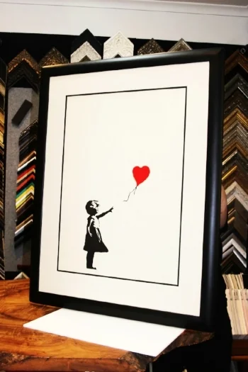 "The Girl with the Red Balloon" , Banksy.  Preservation framed in our hand finished rounded closed corner profile.