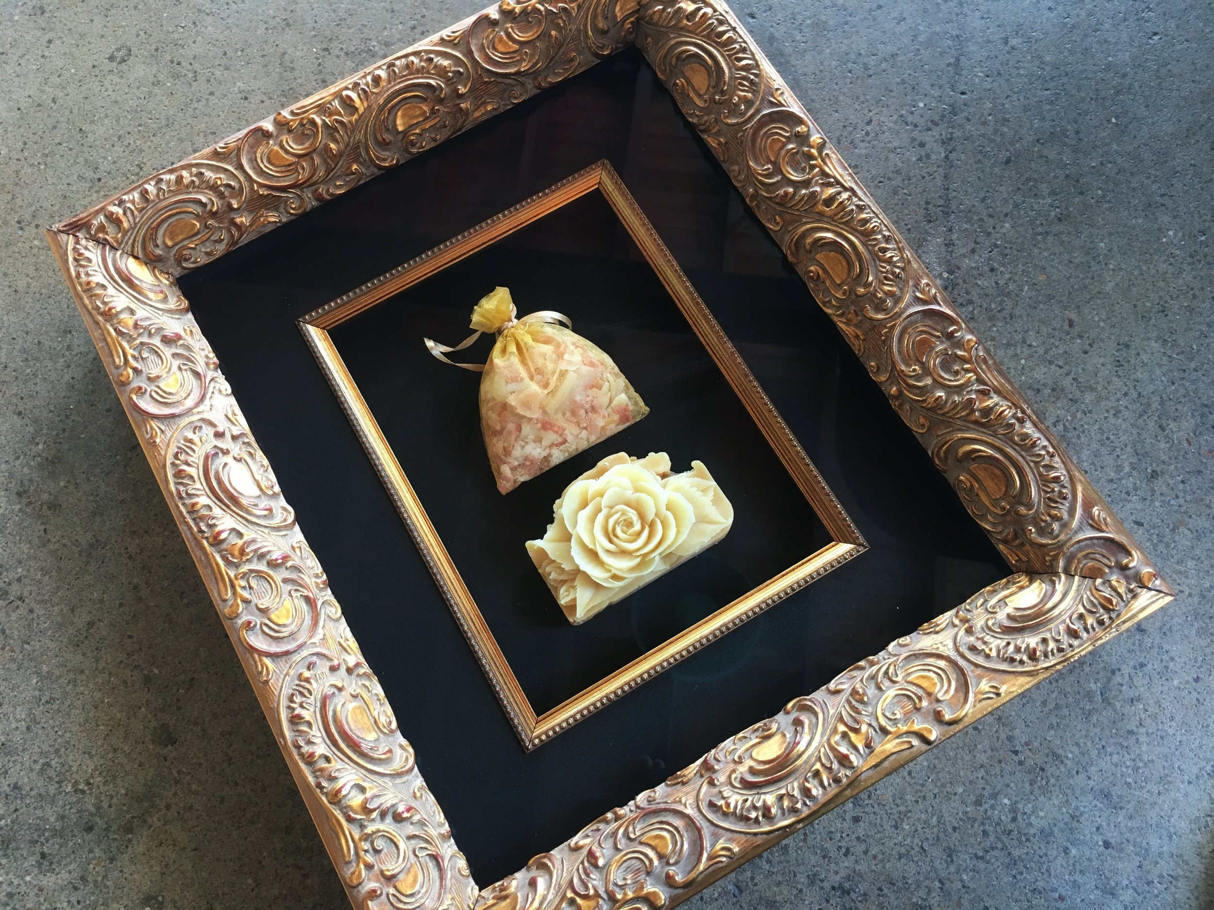 Carved soap framed. Ornate gold frame, black silk matting and a gold fillet trim