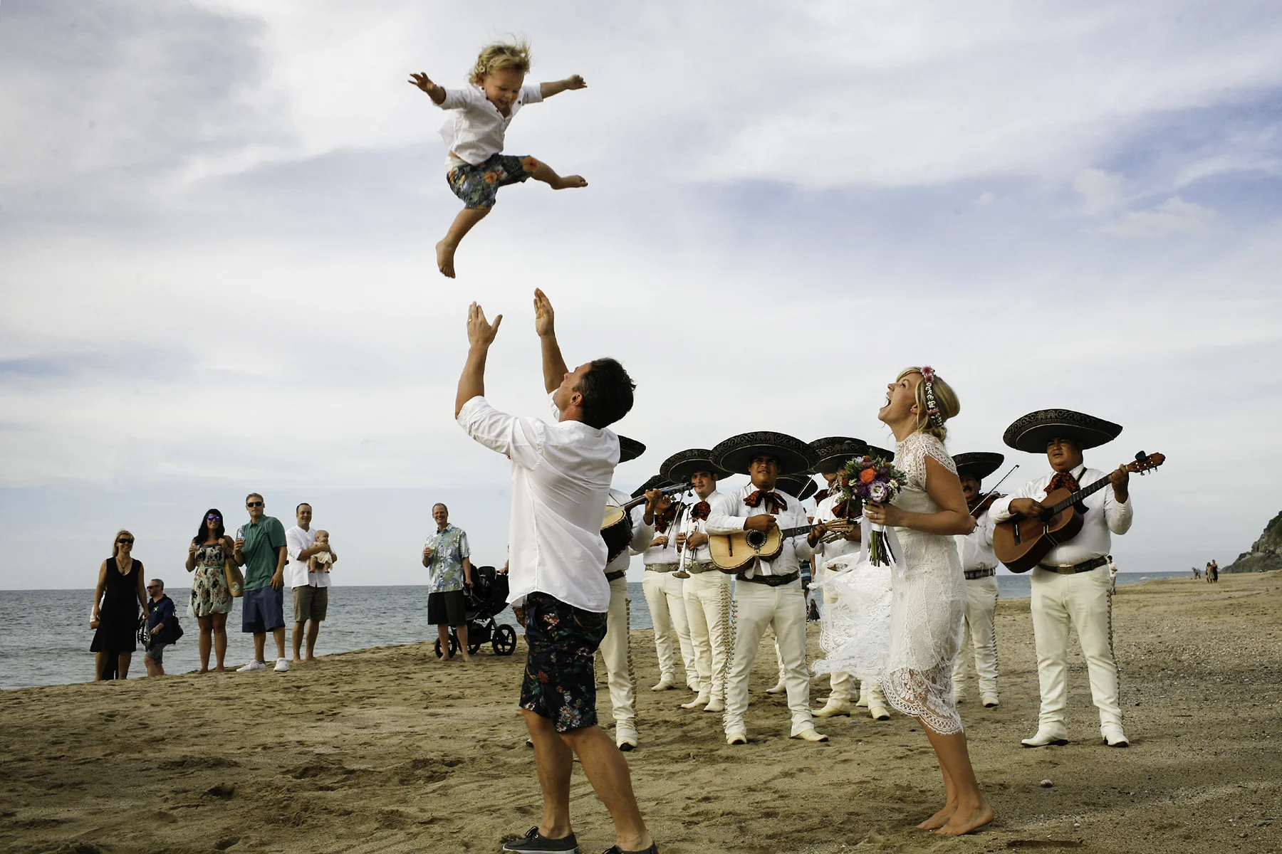 With Mariachi’s strumming behind them, the groom tosses his son (and ringe bearer) high into the sky on the beach in San Pancho, Mexico.