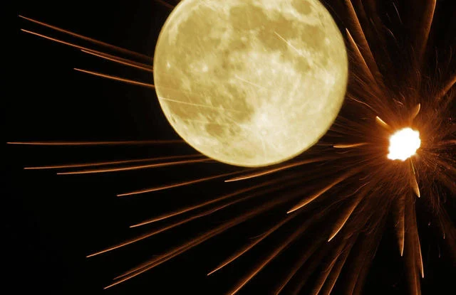 Fireworks exploding in full moon sky during Kansas City Independence Day celebrations ( Charlie Riedel, Associated Press )