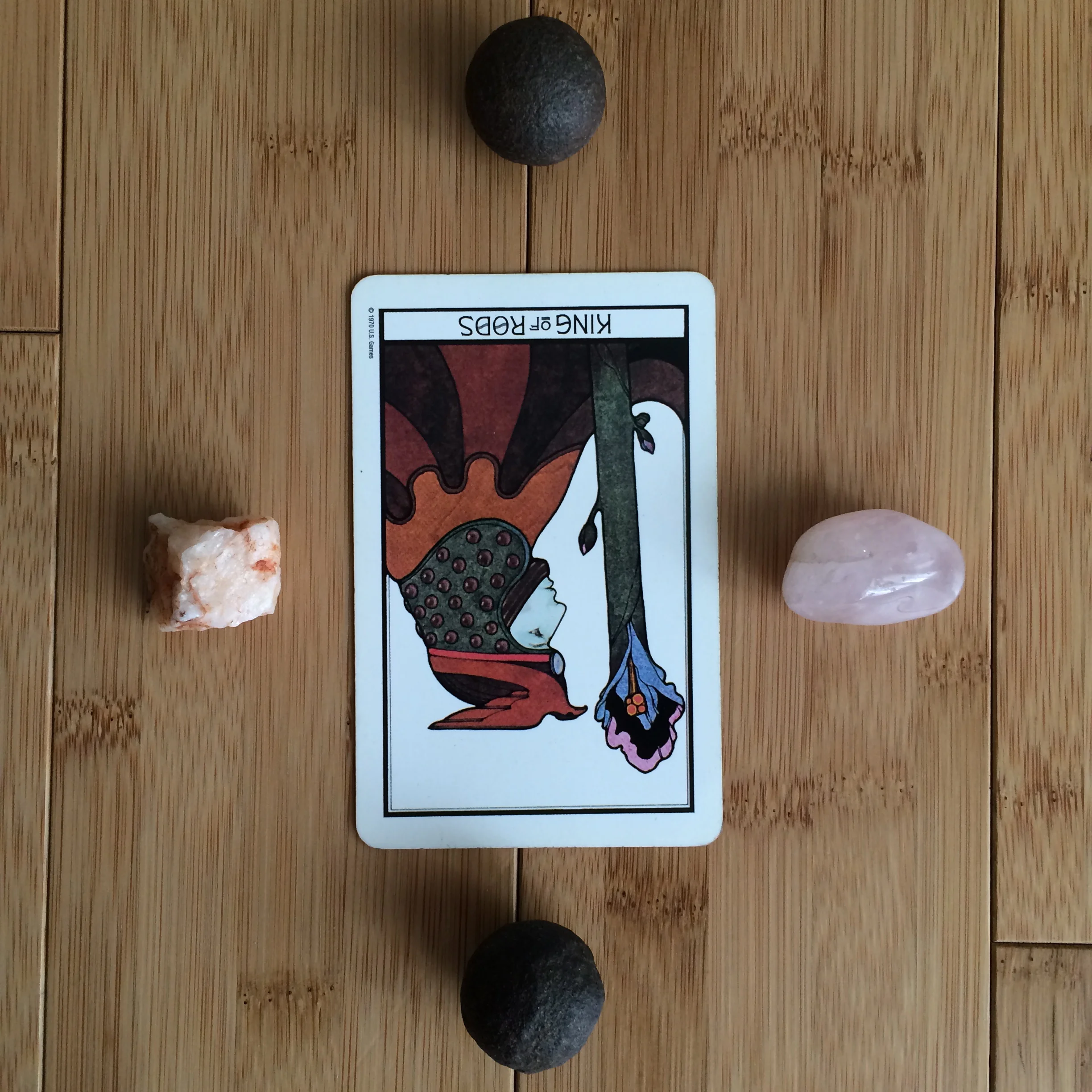 Kings of Rods reversed from Aquarian Tarot Deck . Stones clockwise from left: unrefined quartz, moqui ball, rose quartz, moqui ball