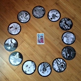 Astrological spread containing The Gorgon's Tarot and Aquarian Tarot cards