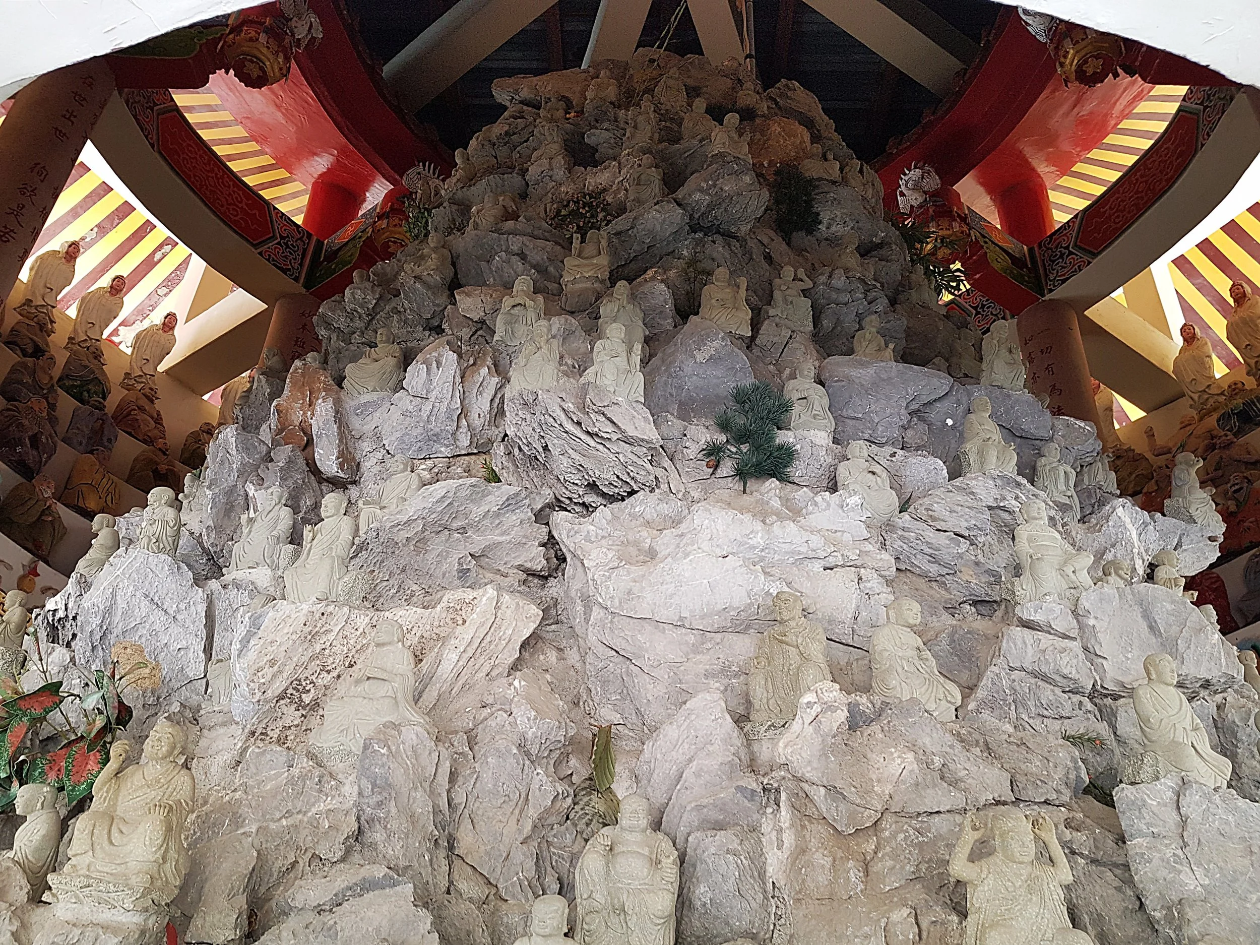 A rock of Buddhas being watched by other Buddhas.