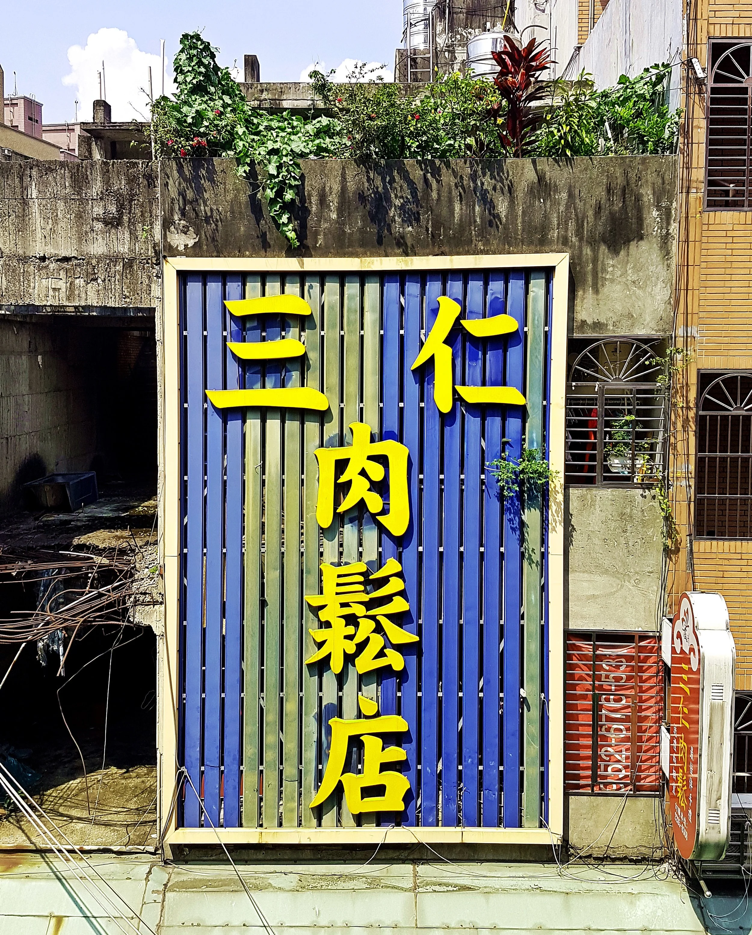 The Sanren Dried Meat Store, an eye-catching sign on a mostly derelict building next to Baohe Temple