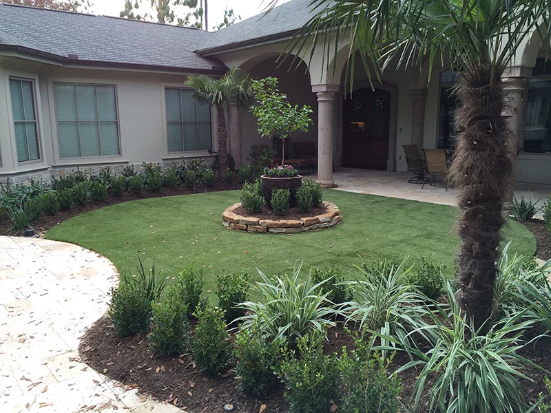 Synthetic-lawn-artificial-turf-courtyard-formal-travertine-The-Woodlands-carlton-woods-travertine-deck-landsacpe-best-maintenance-spring-tx-houston.jpg