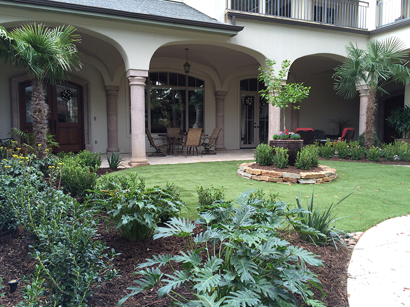 Tuscan-courtyard-palm-tree-boxwood-flax-lily-moss-rock-stcaker-stacked-wall-urn-lemon-tree-ligularia-xanadu-synthetic-artificial-turf-grass-custom-design-The-Woodlands-houston-spring-cypress.jpg