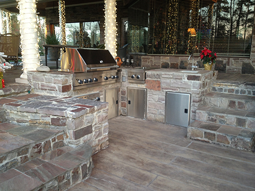 outdoor-kitchen-patio-deck-grill-built-in-stone-stamped-concrete-custom-design-covered-new-construction-builder-installation-best-top-company-the-woodlands-spring-cypress-montgomery-carlton-woods-houston-living-luxury-landscape-residential.jpg