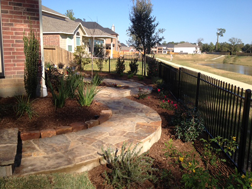 wrought-iron-fence-lake-view-walkway-patioo-decking-stone-design-maintenance-flagstone-installation-installer-aggie-owned-pool-landscaping-the-woodlands-houston-spring-magnolia-conroe-montgomery-cypress.jpg