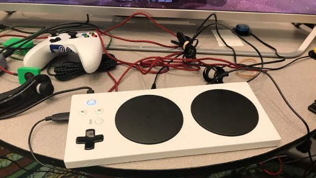 Microsoft Xbox adaptive controller unboxed and next to a traditional Xbox controller