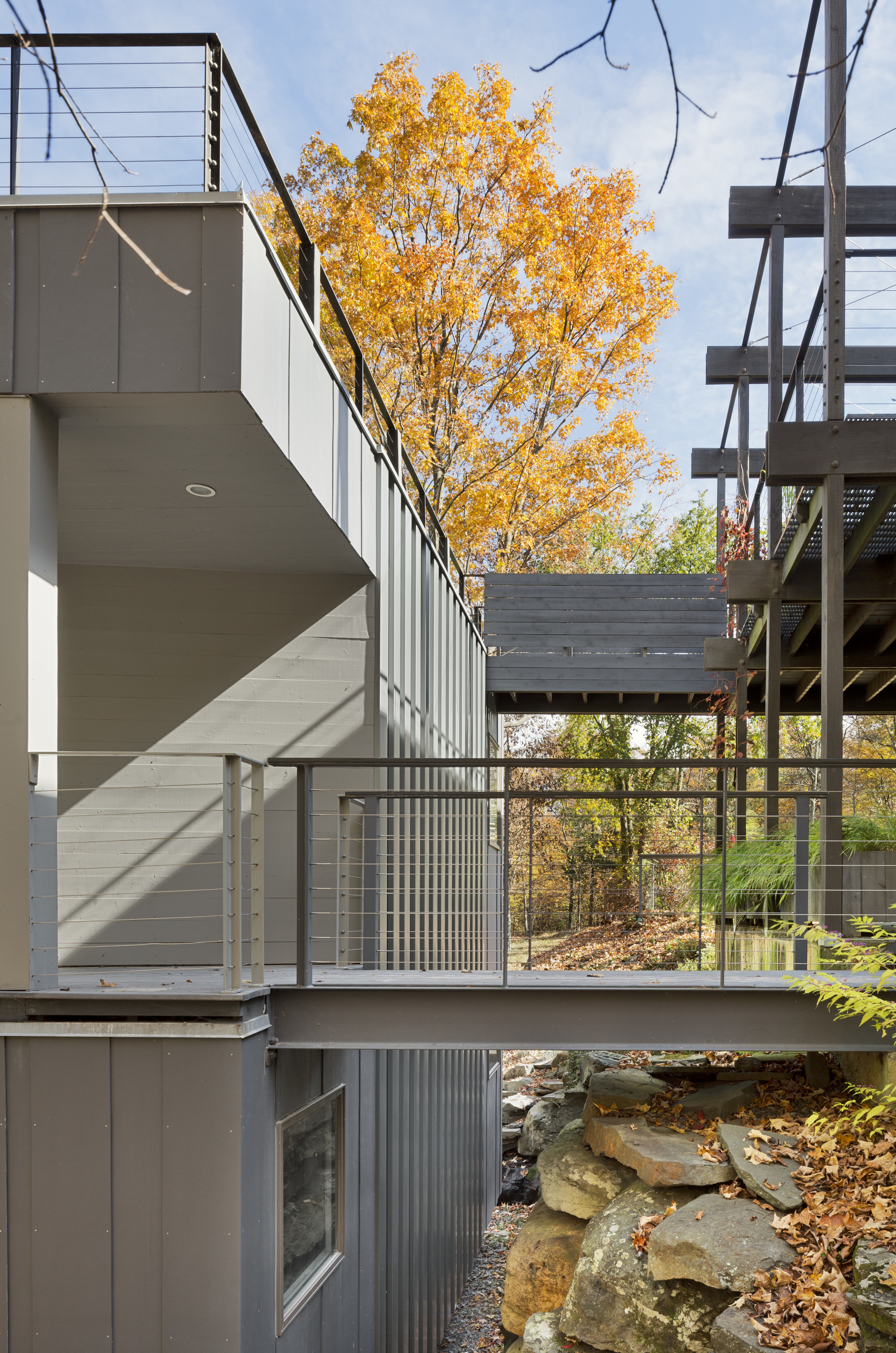 A retaining wall of stones gathered from the site directs the water flow, and defines the change in elevation between house and studio. 