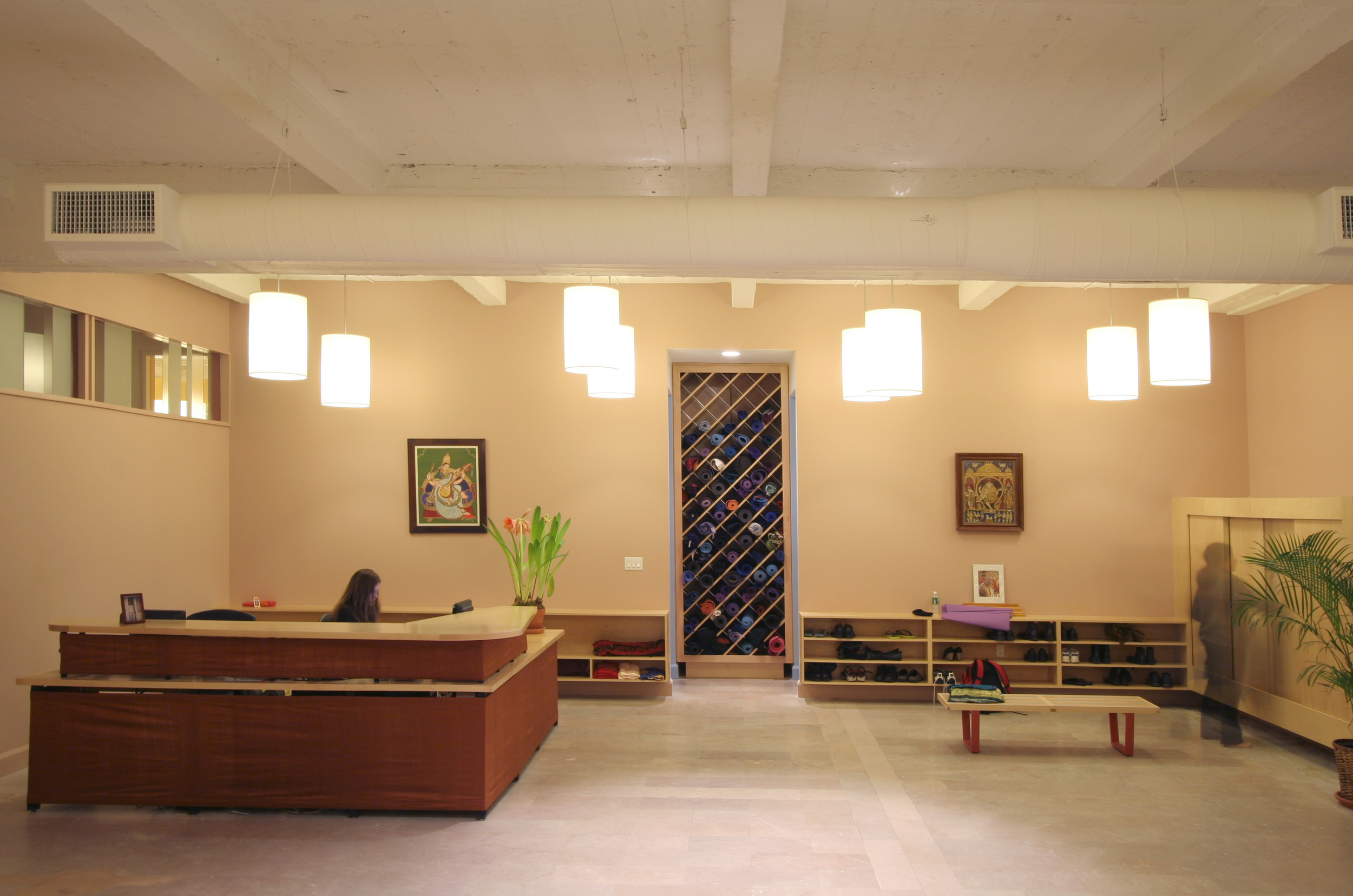 Gans studio designed two schools for Yoga Sutra, one in New York City and one in Philadelphia, each with multiple practice rooms, teaching and lecture areas. In the New York school, studios border a large reception area that doubles as a lecture and reception space. The reception desk is wrapped in silk sari material. The diagonal gridded cabinet holds mats.