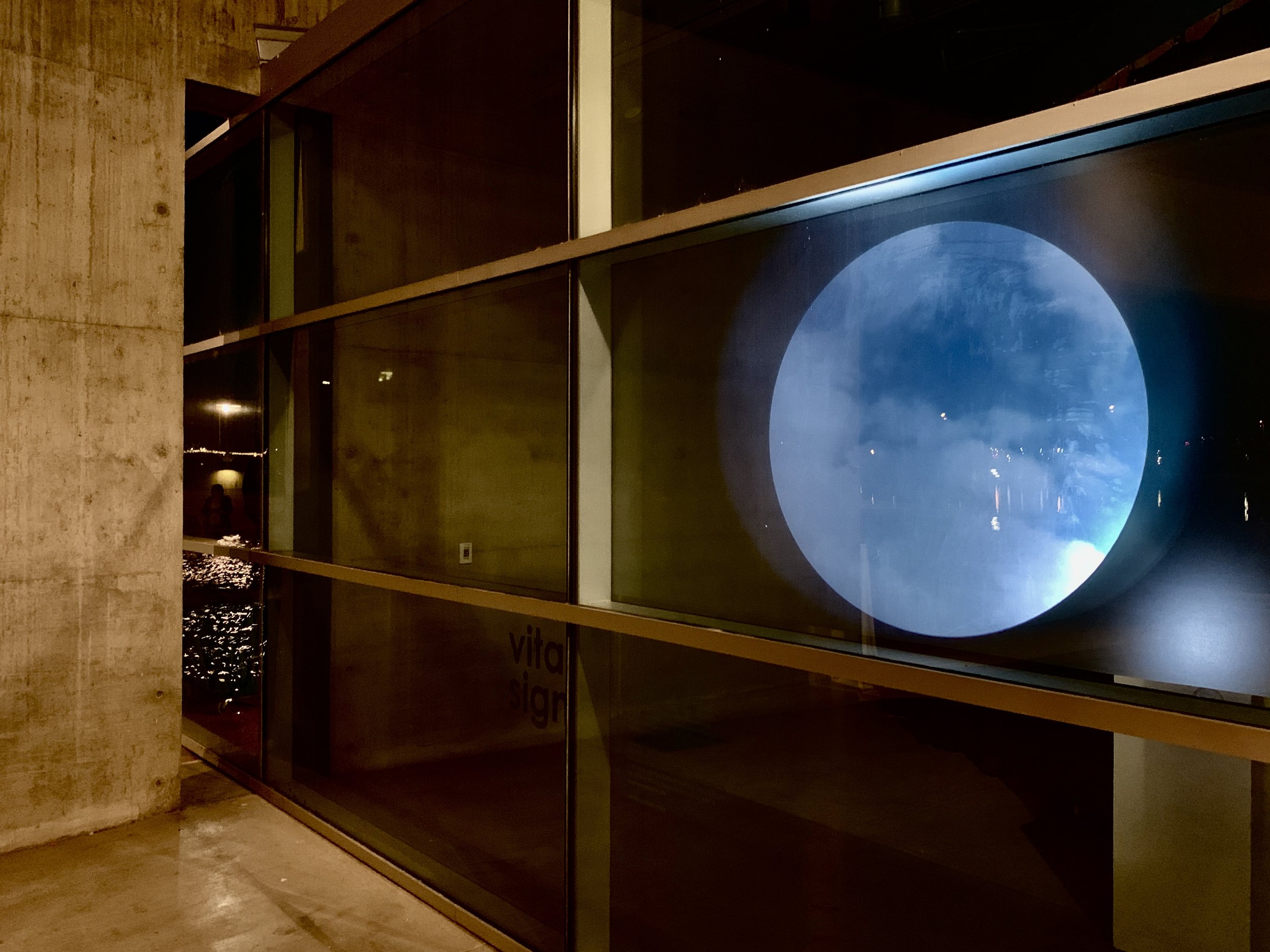 rear projection of digital video art created through daily documentation of the sky during the covid19 pandemic through a window of clouds in a circular cutout shape