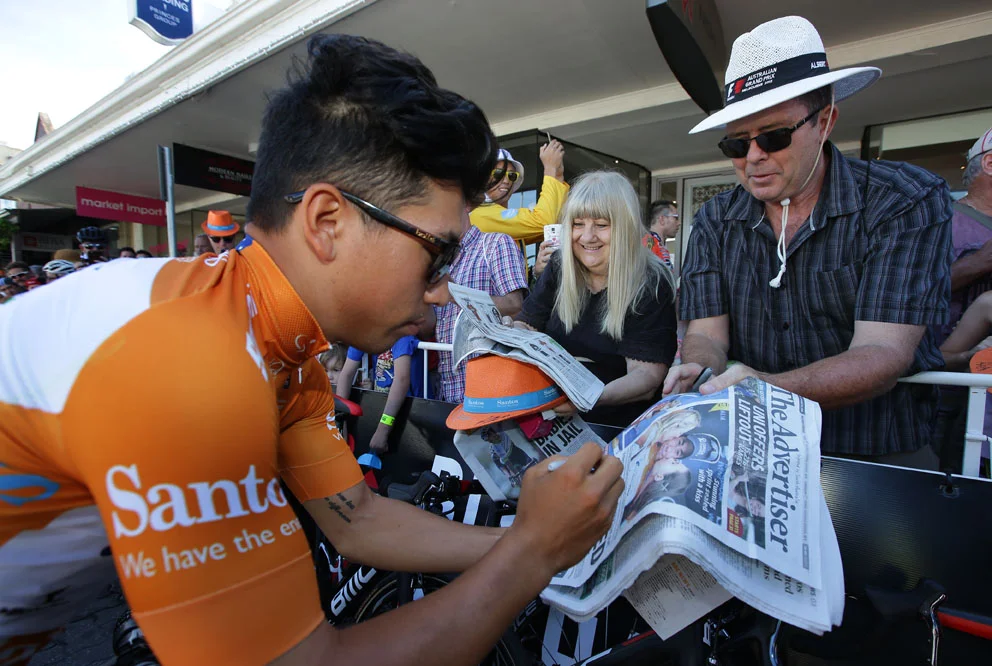 Stage2e-Ochre Jersey wearer Caleb Ewan signs autographs for the fans at race start