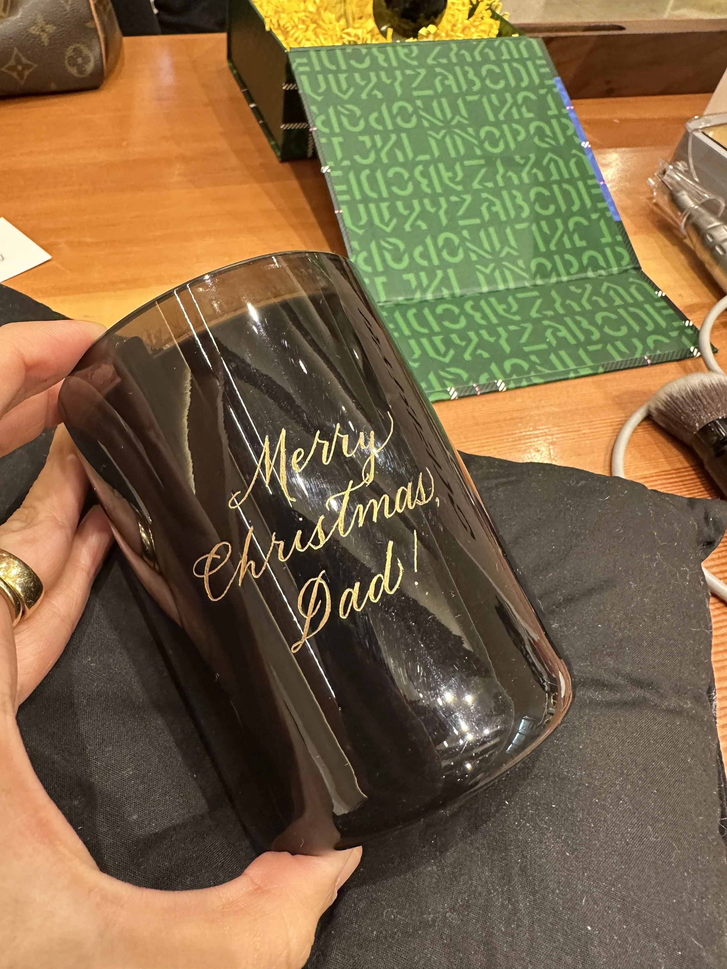 Gold calligraphy engraving on candle for luxury holiday activation in NYC