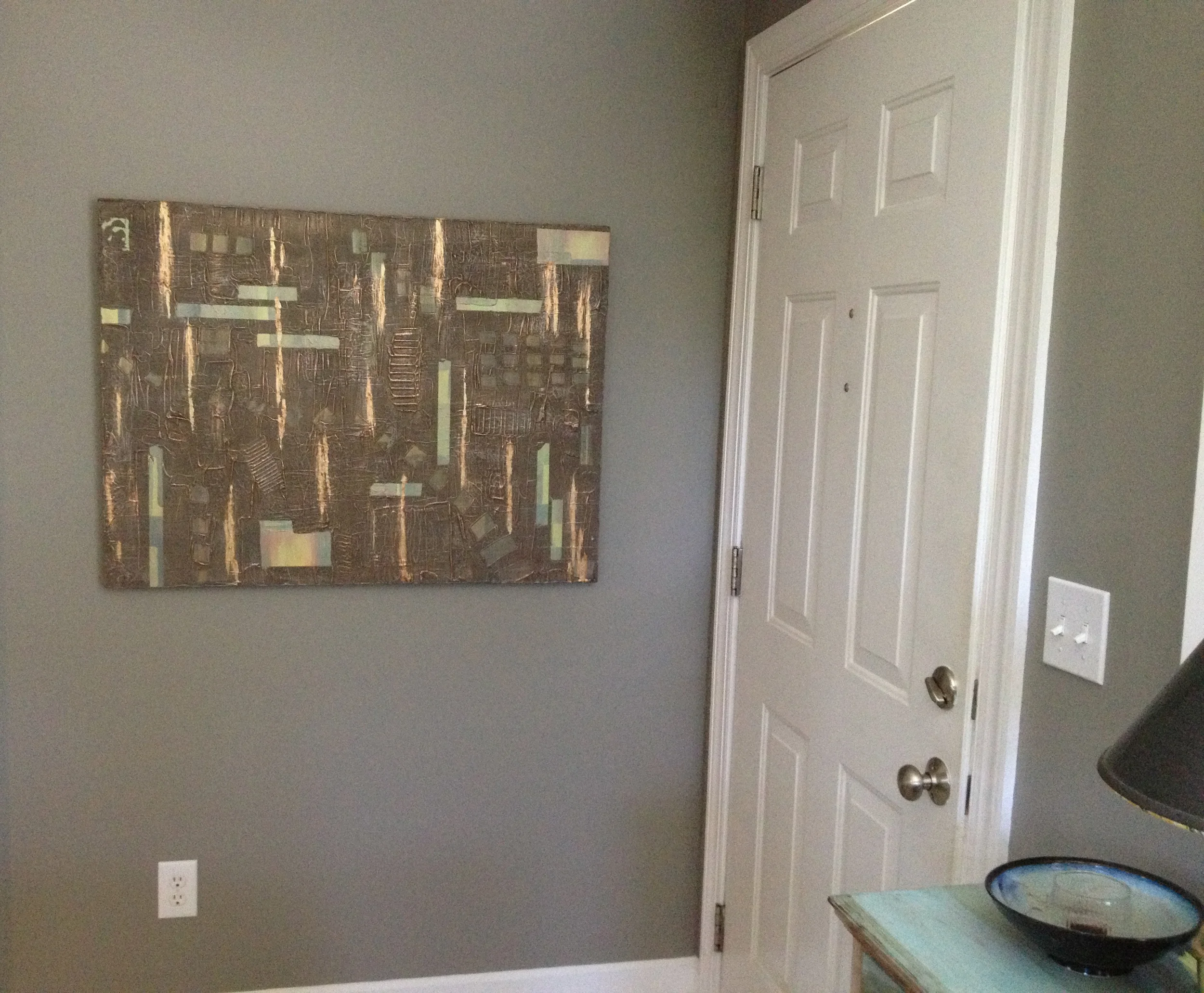 Shown hanging horizontally on a gray wall.