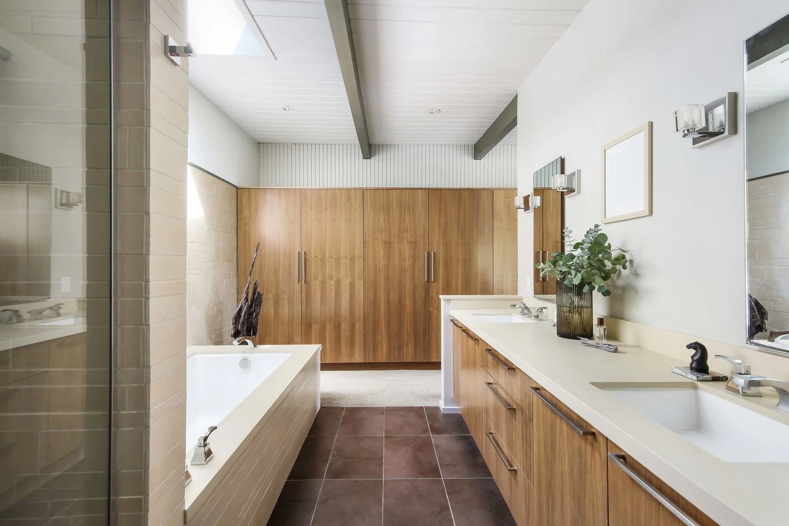 Mason Jay in-the-bathroom-a-custom-wood-vanity-complements-the-wardrobe-while-a-skylight-illuminates-the-large-soaking-tub.jpg