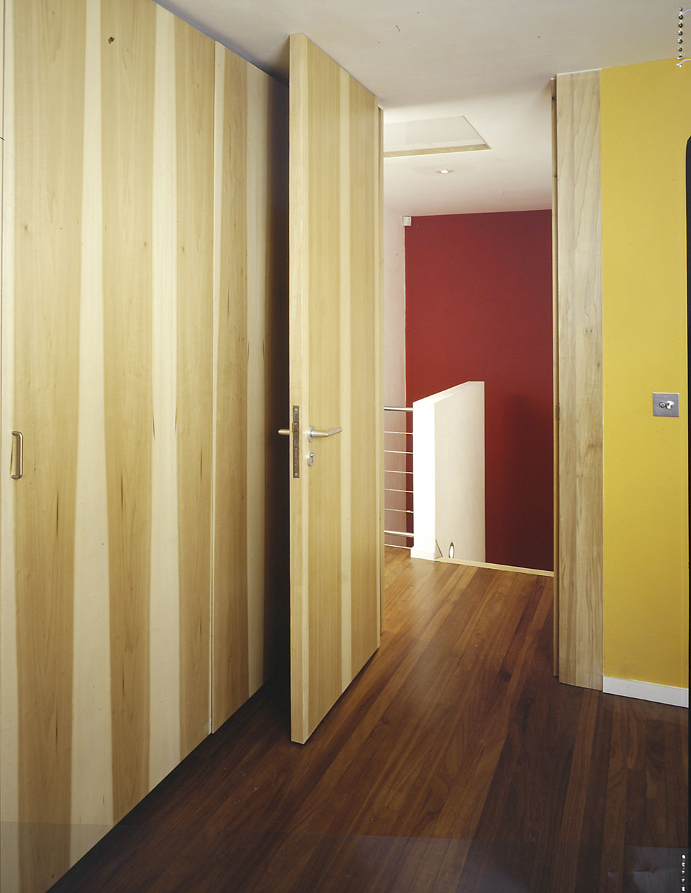 Close-fitting headerless doors show off the beautifully bold linear grain of poplar, or tulip wood, veneer.