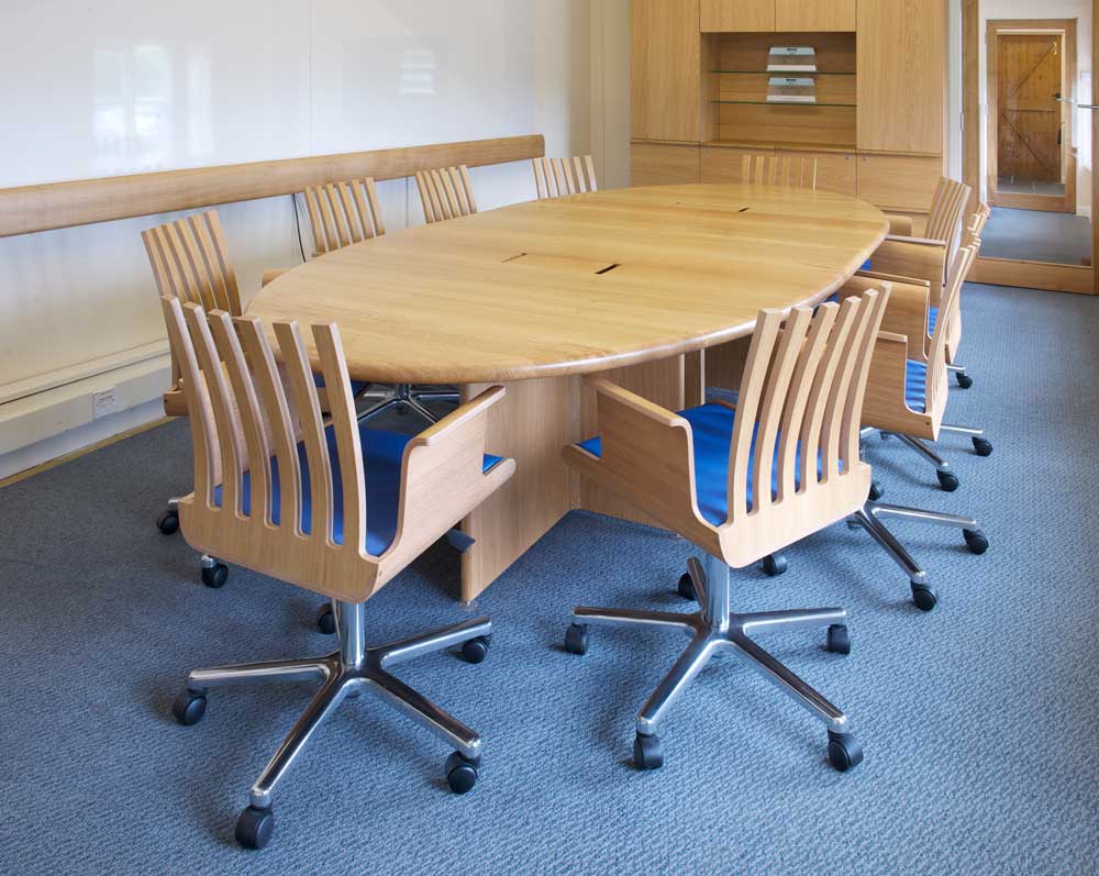 An oval conference table for Risk Factor Solutions incorporates a unique cable management system. The full suite includes a desk and cabinet, and works effortlessly with Ben's 'Rake' bentwood office chairs.