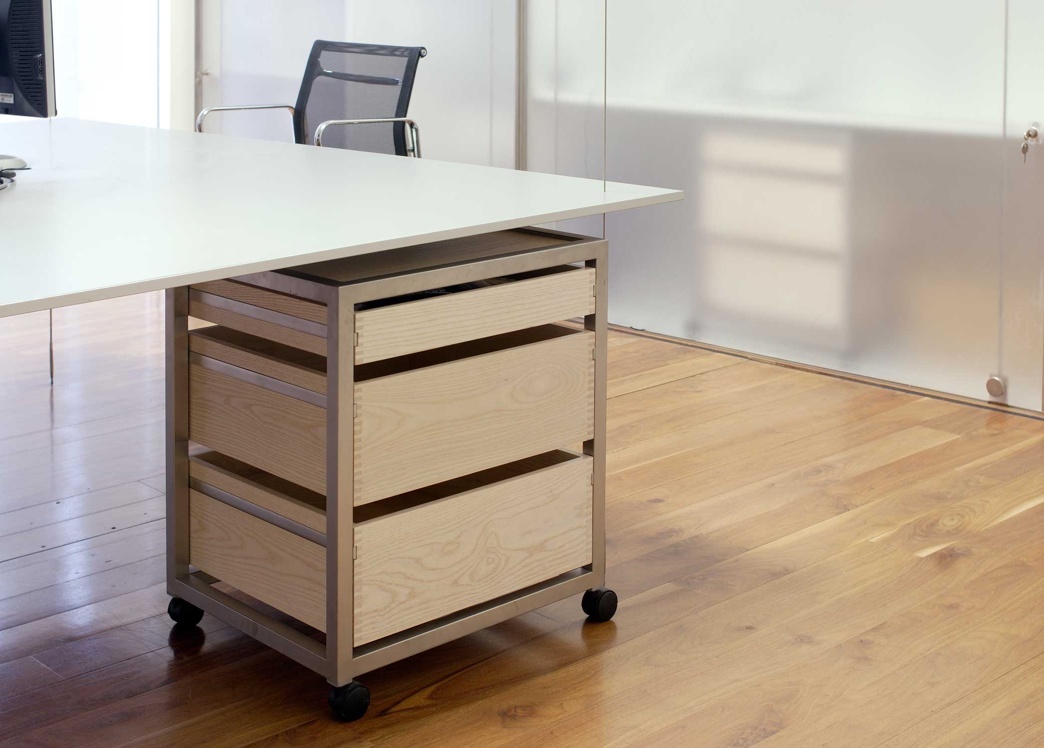 This suspended conference table was designed for the hi-tec offices at Psion. The storage trolleys slide neatly underneath, providing a fuctional strage solution for a fast-moving company.
