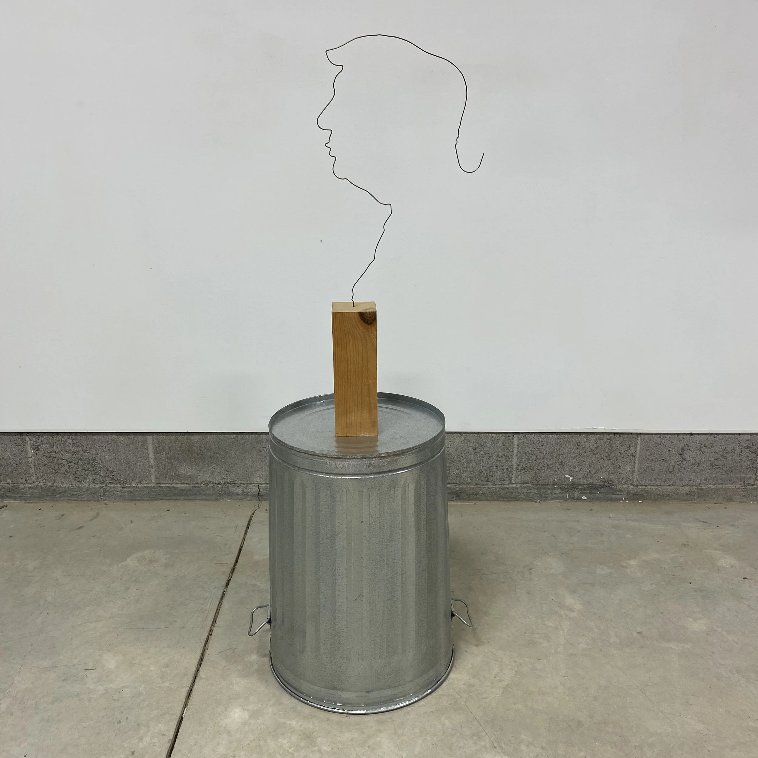  Hendrika Sonnenberg and Chris Hanson   Why is this even a thing? , 2018 - 2024  coat hanger, wood and steel garbage can  54 × 24 × 18” 