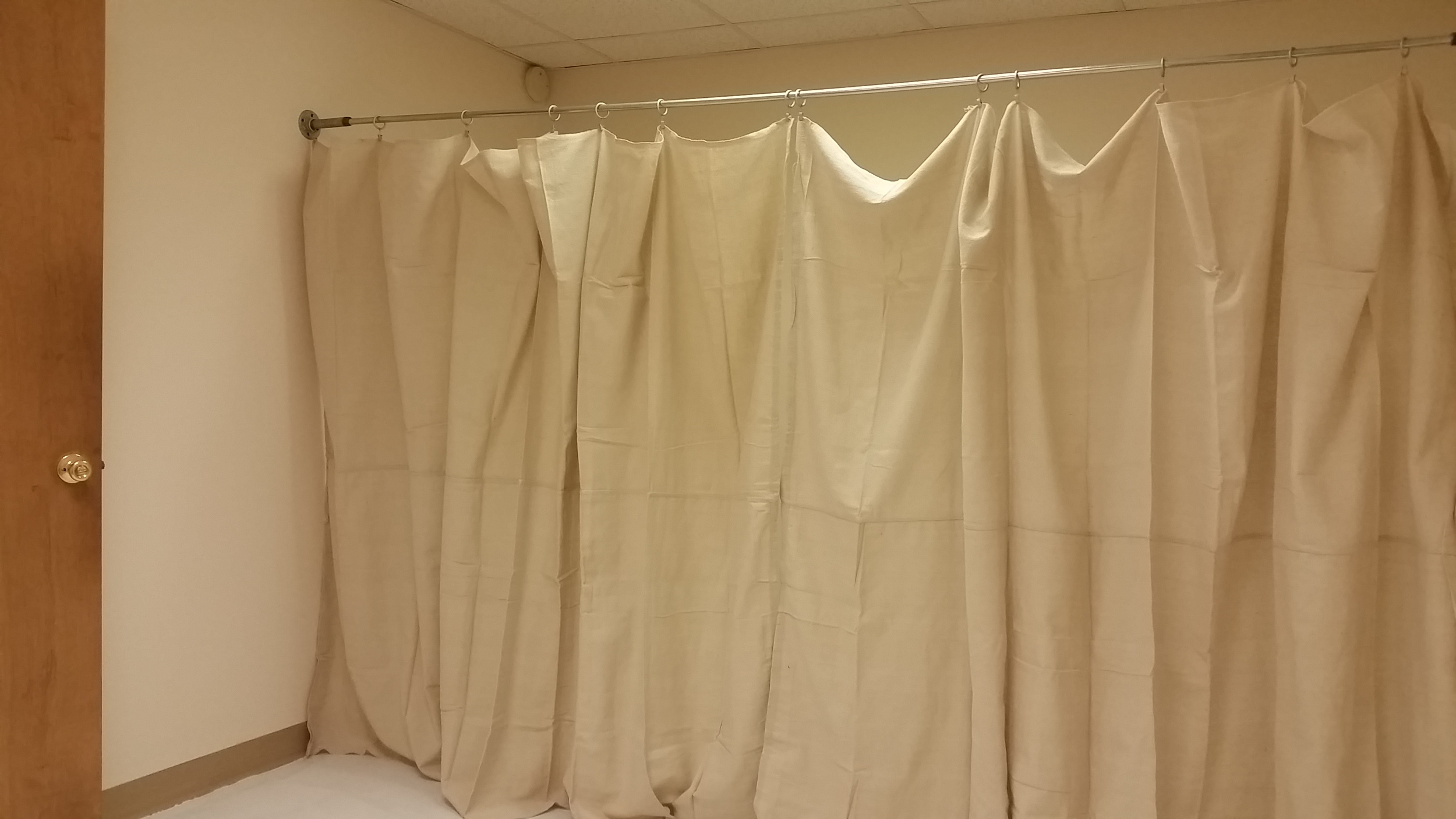 Storage was provided by adding a row of canvas drapery suspended from galvanized pipe fittings and conduit. 
