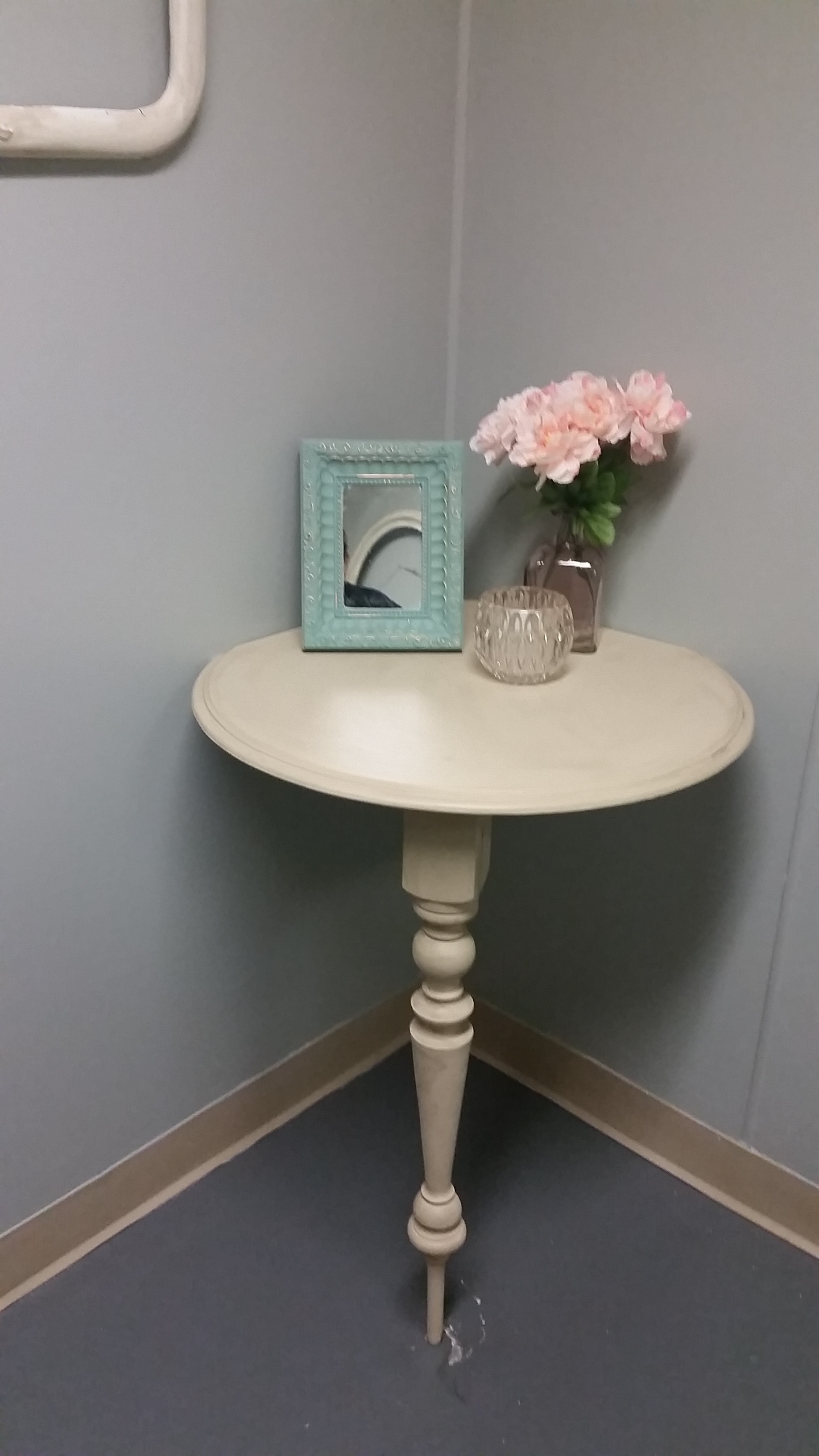 Courtney wanted a vanity in the bathroom, but lack of space and budget concerns led to this quaint solution. A former tabletop gets a corner cut out, supported by cleats and a random table leg, all painted out in one color unifies the found objects. The clients accessories are perfect on the little corner table.