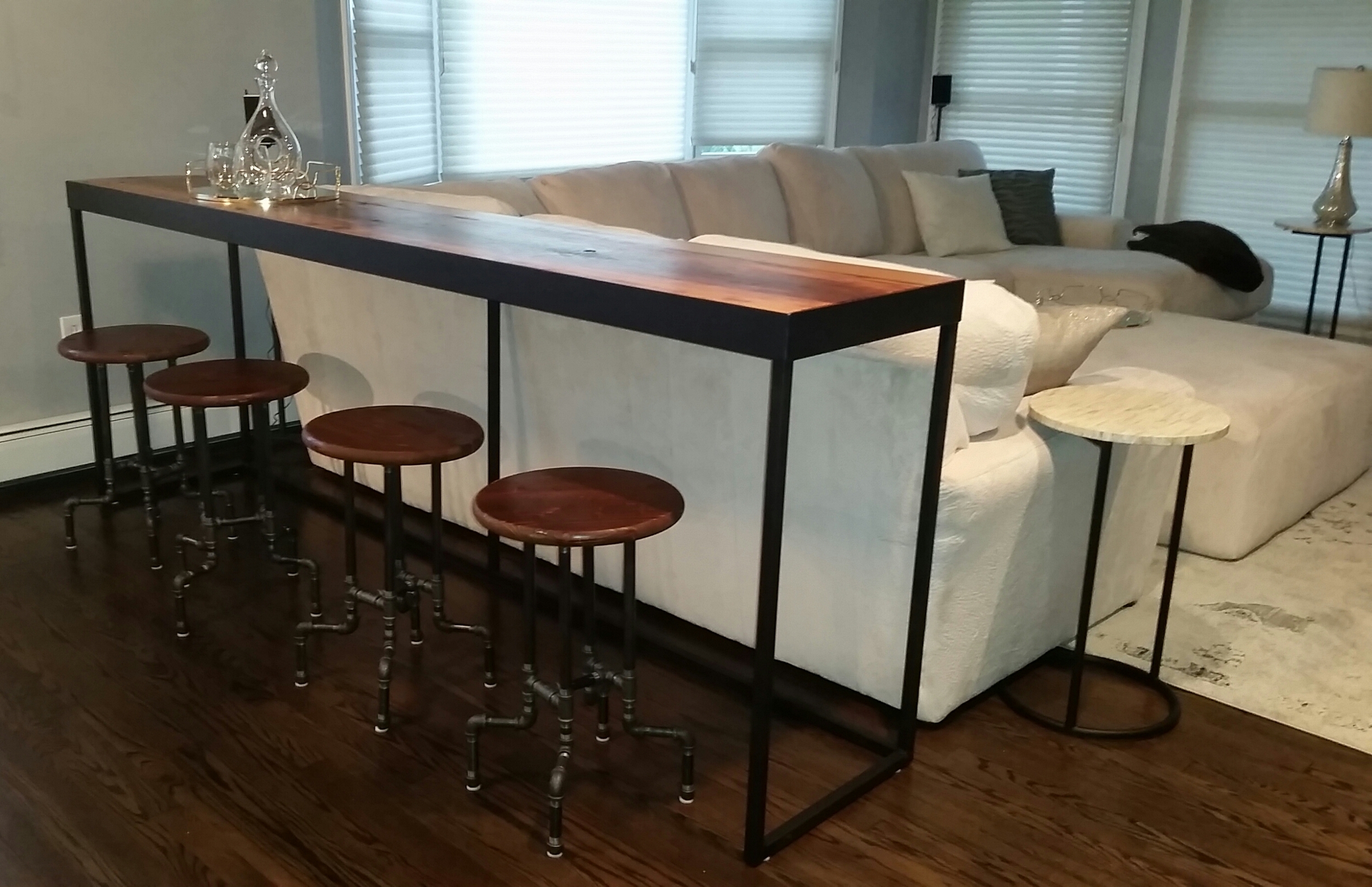 Elements in the new design included some furniture from LaVintage Decor Studio. The wide sofa table was requested by the homeowner and custom built by Dave Beach of Fox Chapel Iron Works. It has since been lowered about 6 inches. The table backs up to their scrumptious modular sofa and allows for casual dining and additional seating when they entertain. The tabletop is made from century old reclaimed hickory wood. The stools are from Dane Noel, another vendor at LaVintage Decor, providing an unexpected industrial vibe. This was the homeowner's suggestion after seeing the stools in the studio. This couple was so easy to work with because they knew exactly what they wanted, yet they were open to suggestions. In an adjoining bathroom/laundry room, they chose a towel rack and toilet tissue holder, also from Dane Noel, in the same industrial style. Their choice in those accessories, along with keeping the color of the walls and cabinets consistent make the whole living space cohesive. Stop in to the studio to see the bath accessories they chose and see if they would work in your interior!