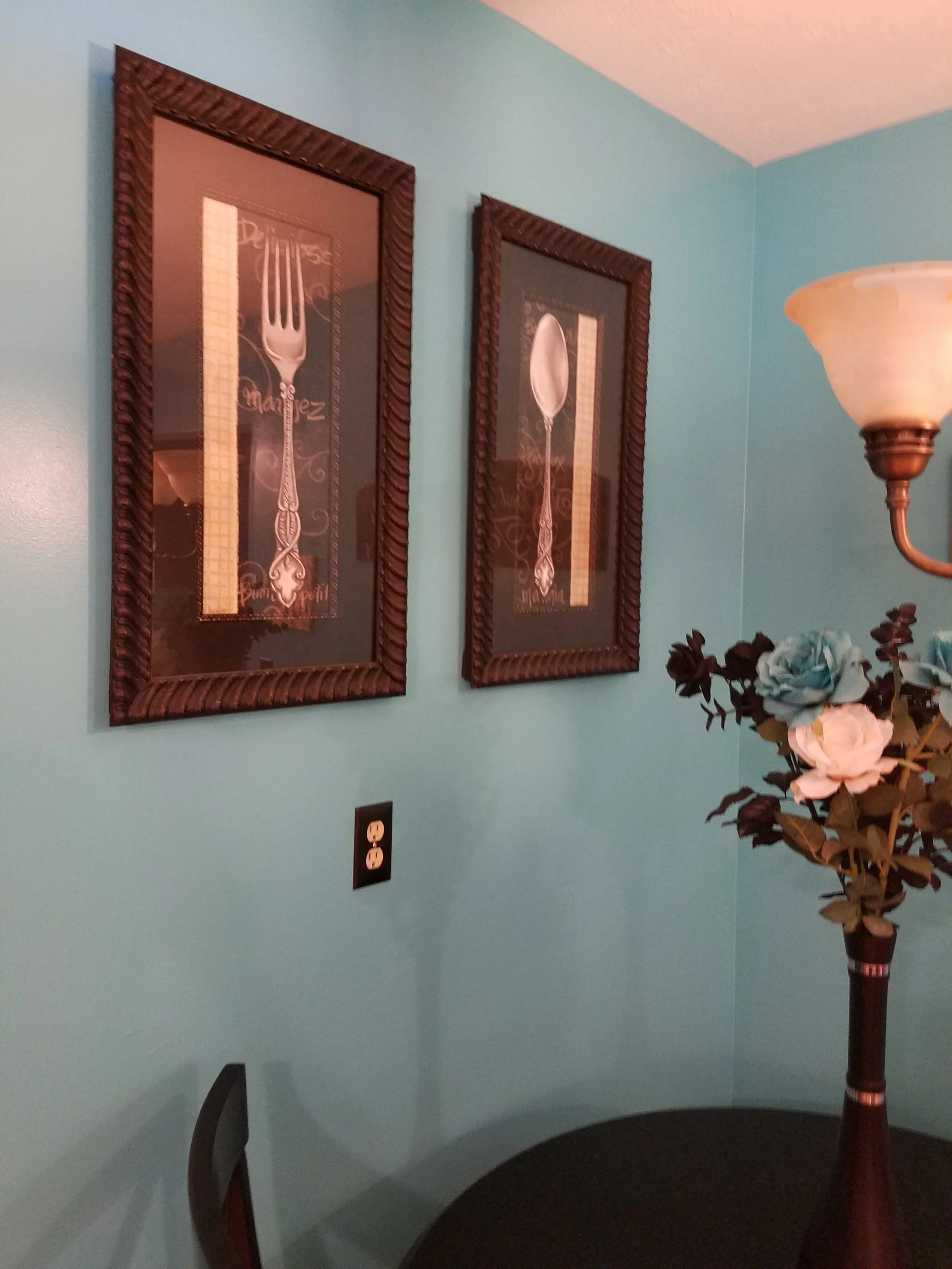 The homeowner had lovely graphic wall art of a fork and spoon. She had considered replacing it, but it took on new life, with the bold new wall color. The black table and chairs also pop off the color.