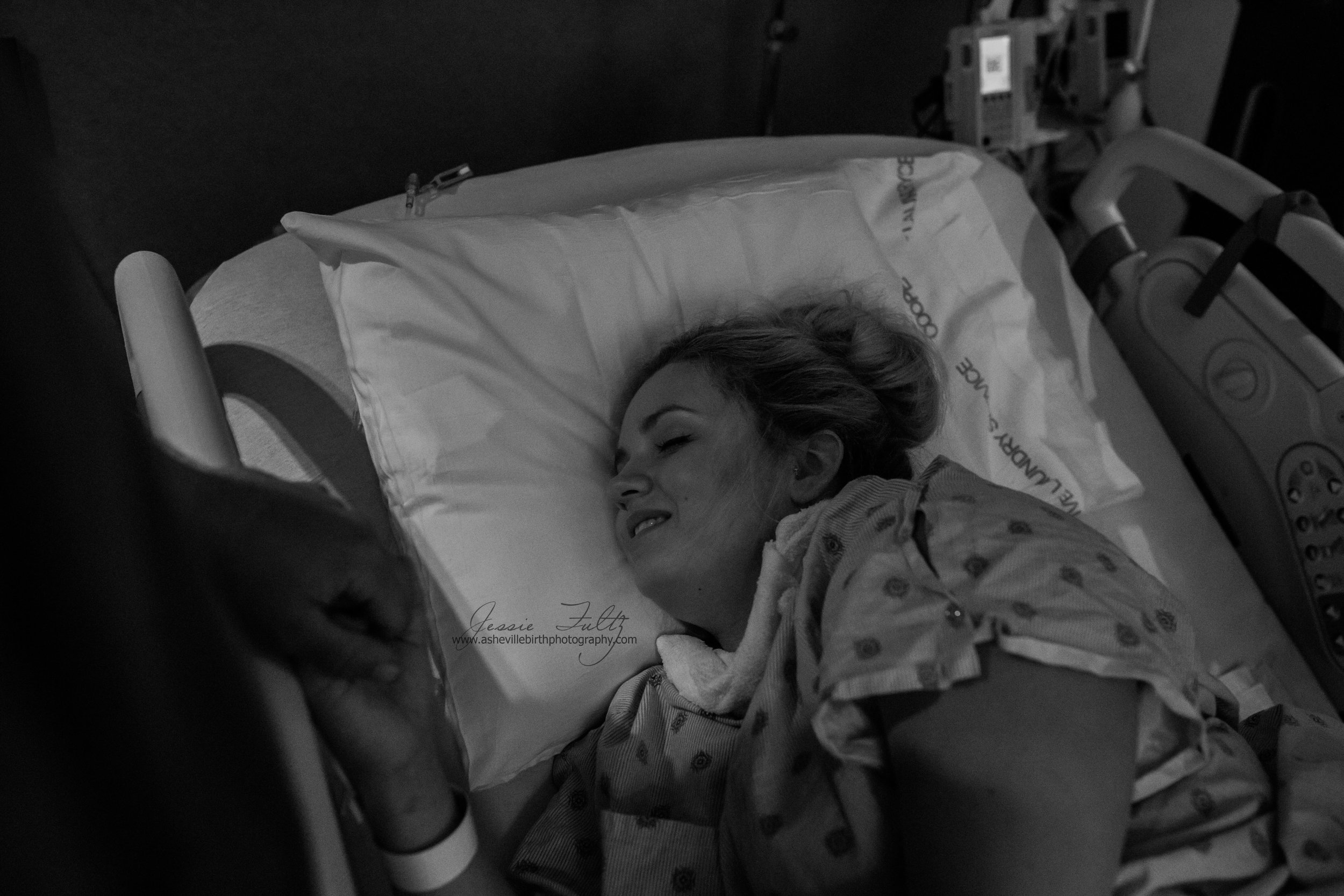 a laboring woman on a hospital bed smiling between contractions