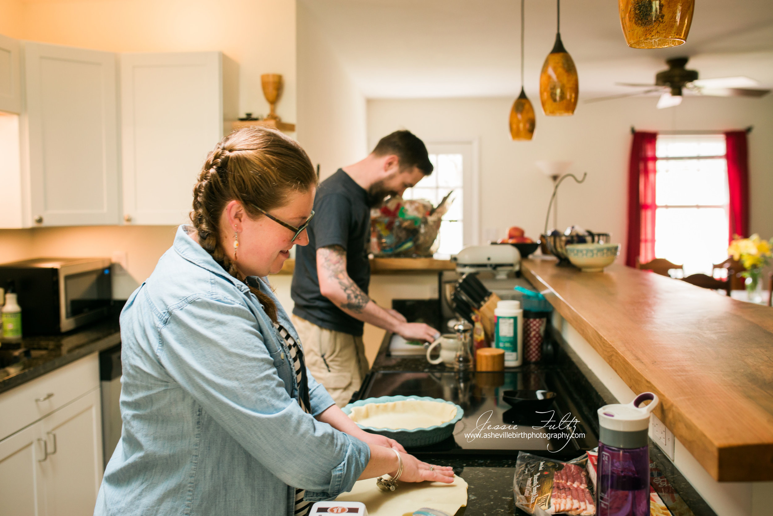 red-headed pregnant woman and husband making pie crusts in kitchen