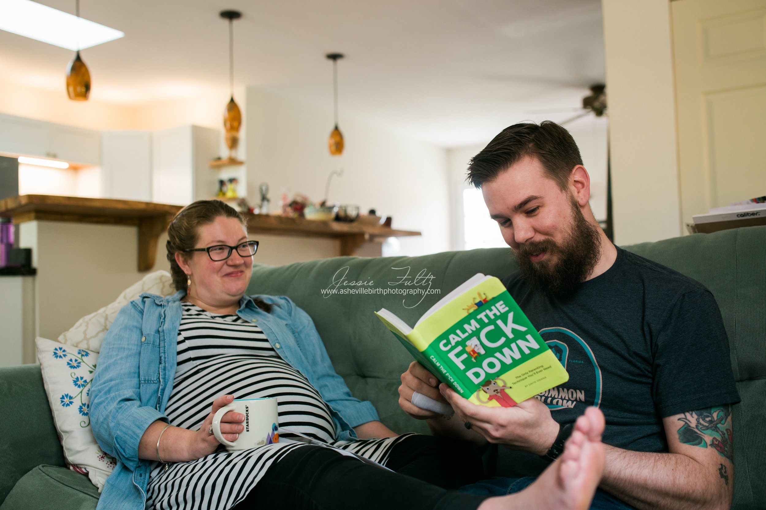 pregnant wife and husband sitting on couch laughing as husband reads a book called "Calm the F*ck Down"