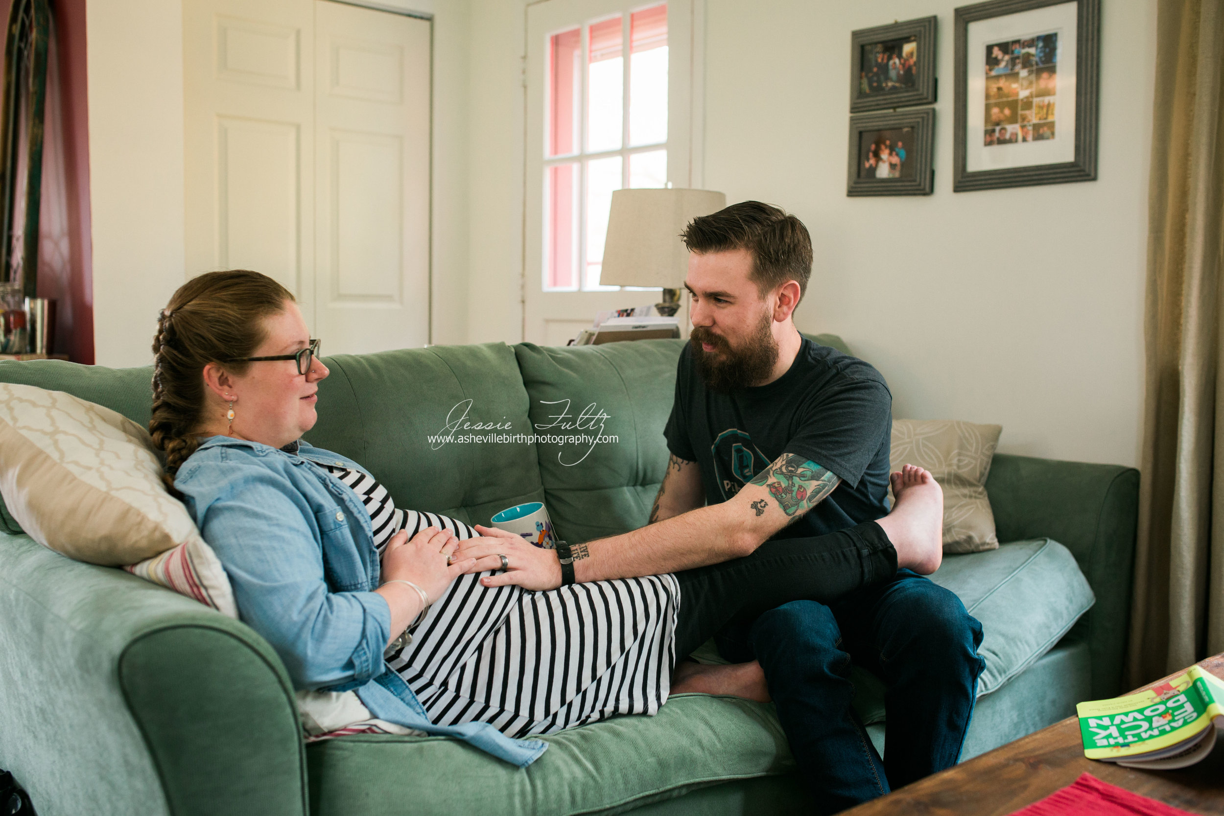 a pregnant woman and her husband looking at each other as they feel their baby kick