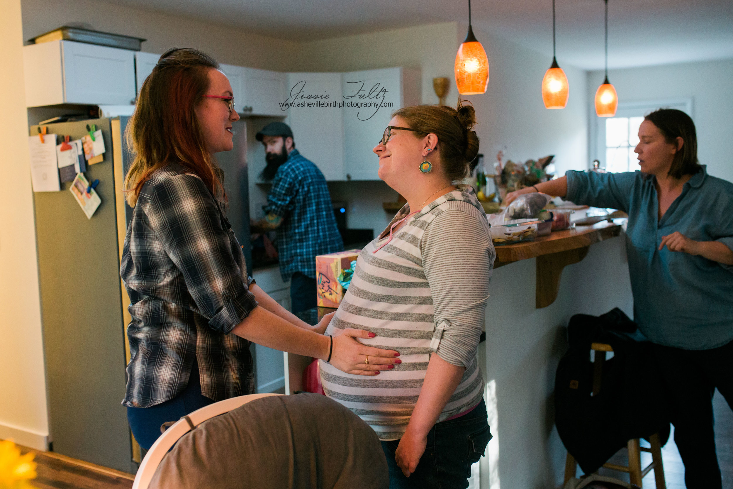 a woman holding her friend's pregnant belly and talking to her
